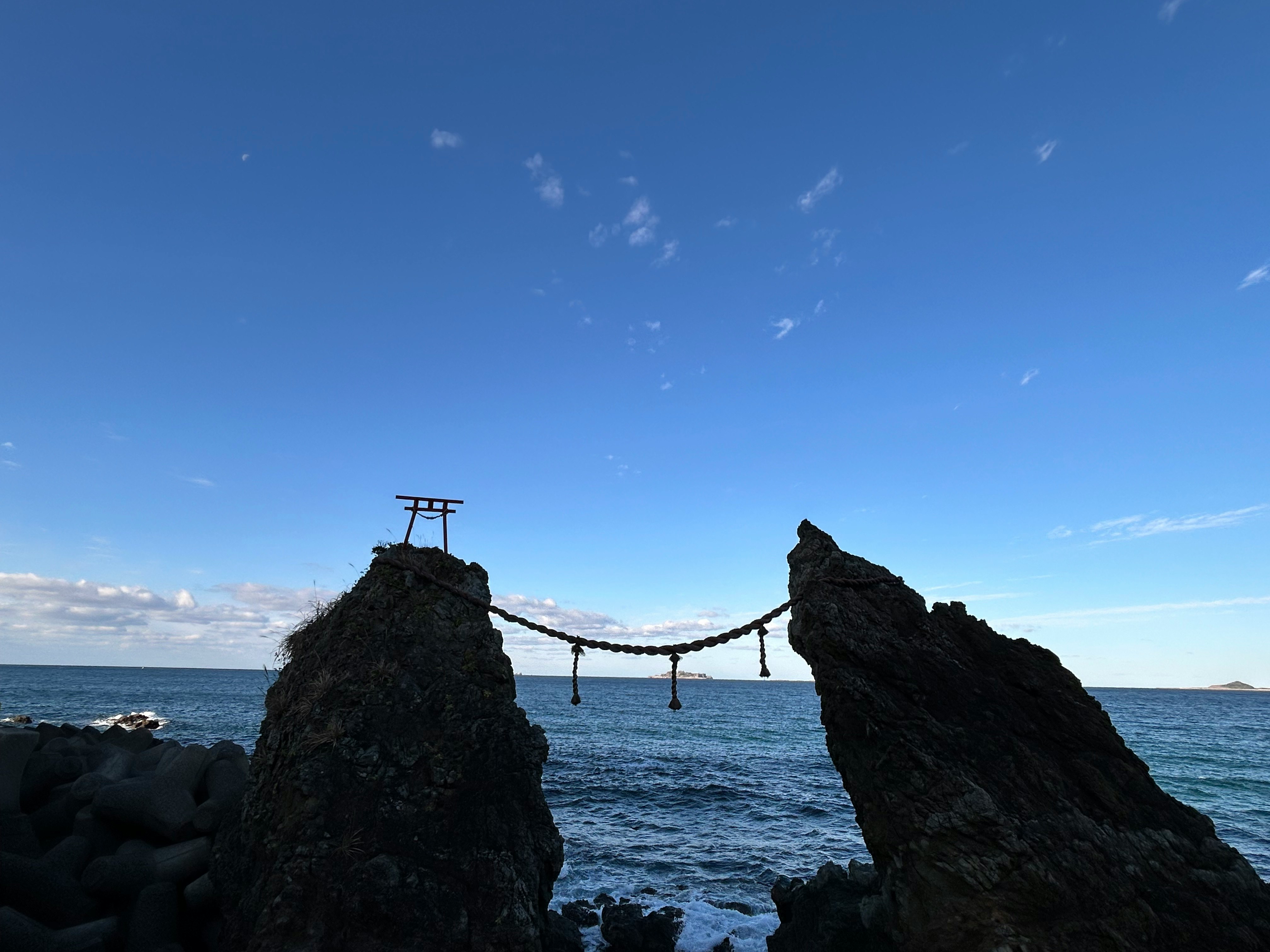 冬の海に浮かぶ岩と張り渡されたロープの景色