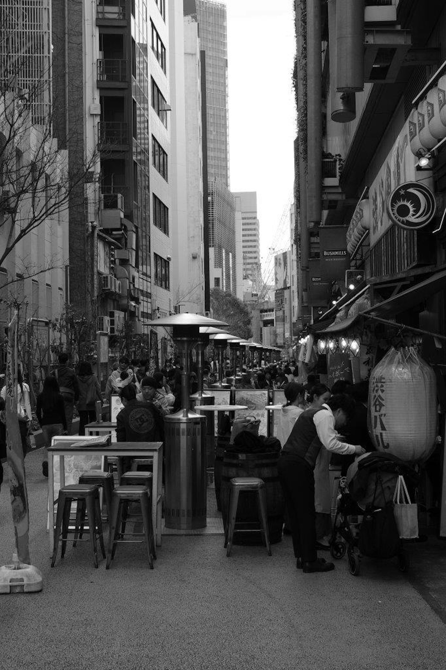 黑白照片，街道两旁是咖啡馆和餐厅