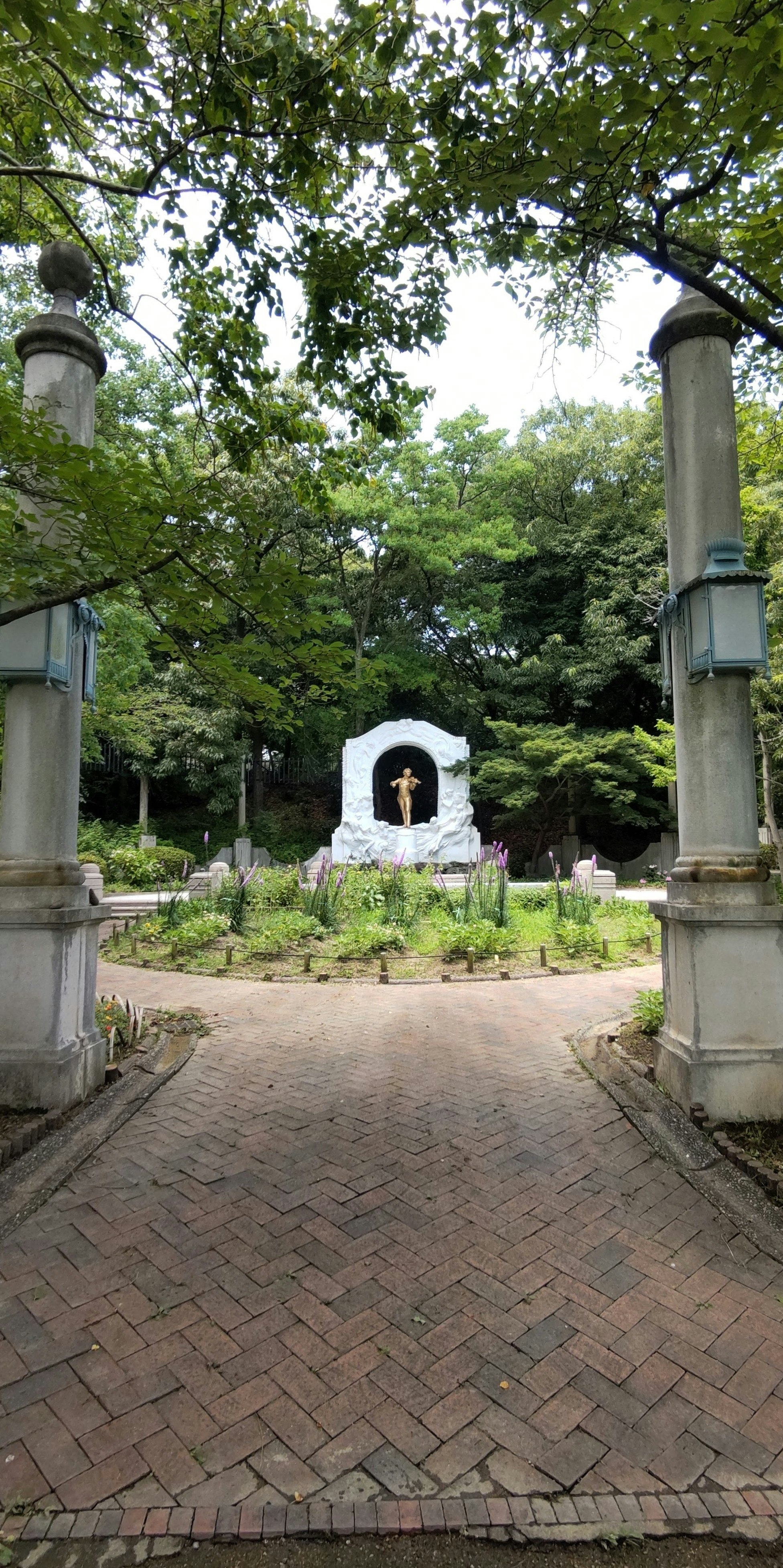 緑に囲まれた石造りの小道と門のある庭園