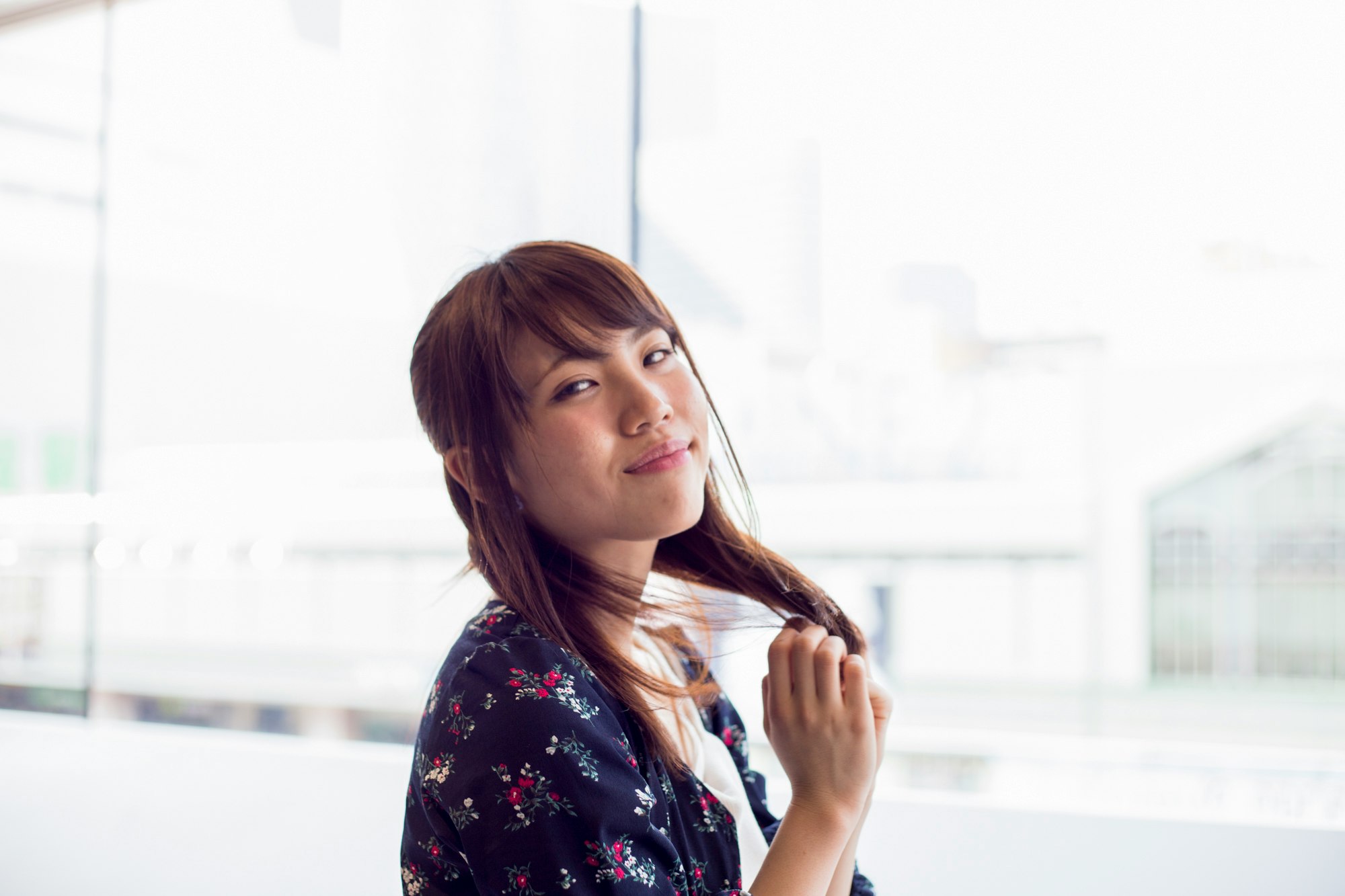 窓のある室内で微笑む女性