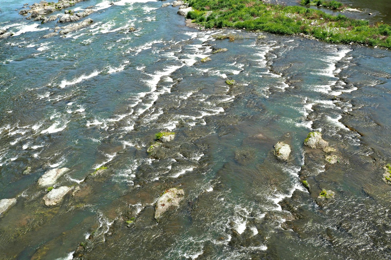 Pemandangan udara sungai dengan air mengalir dan batu yang terlihat