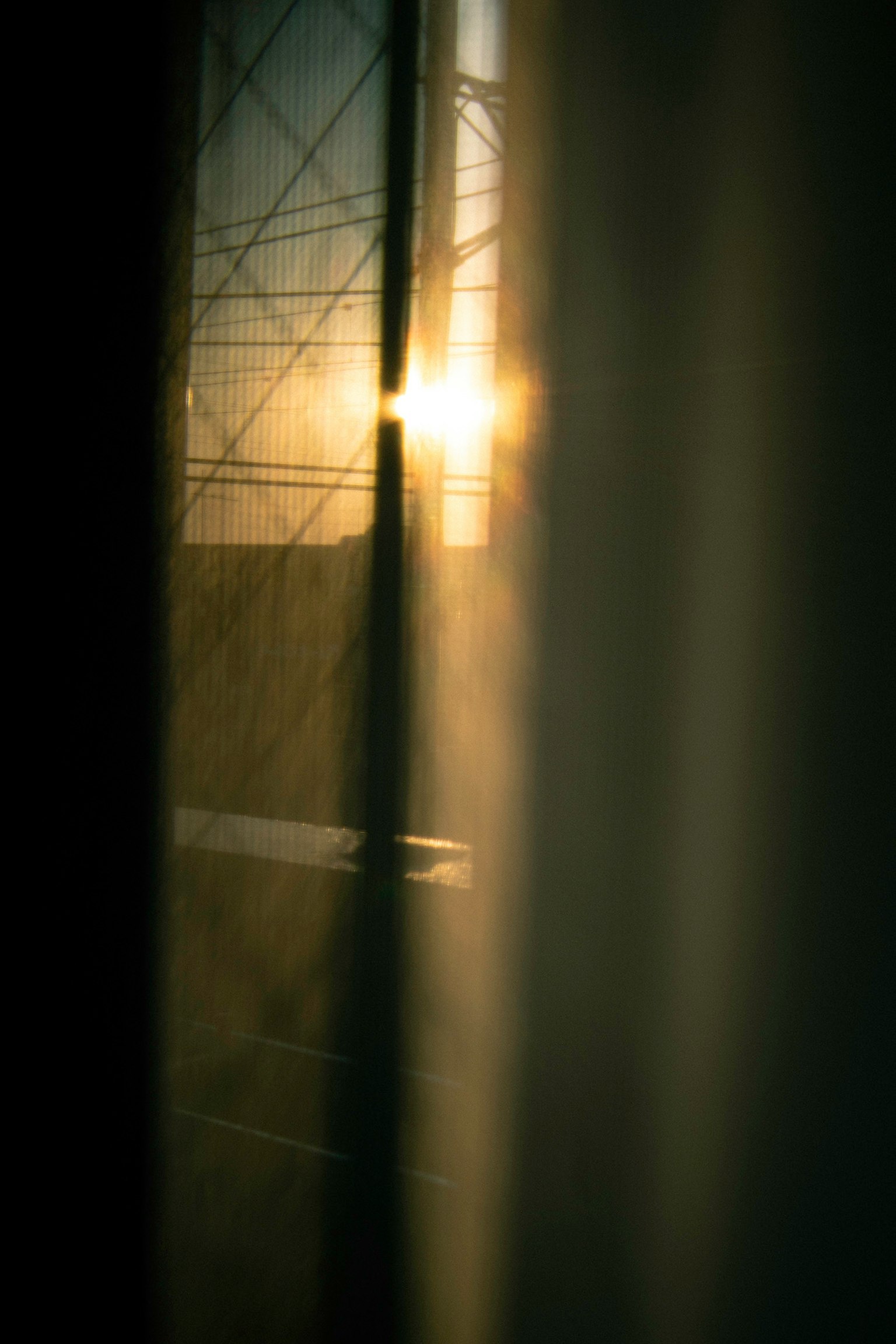 Luce solare che filtra attraverso una tenda con silhouette e linee