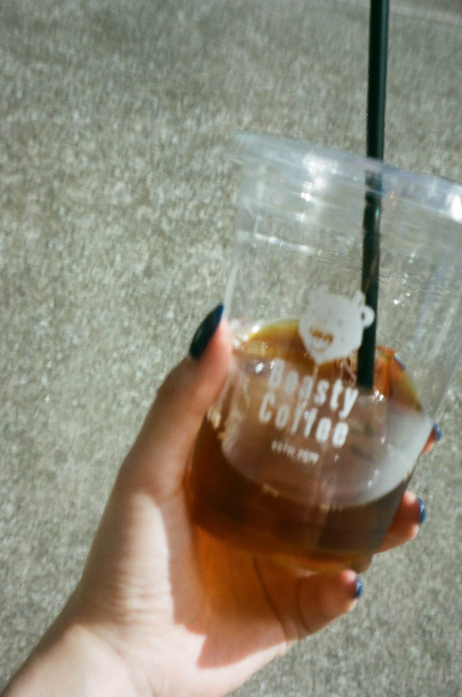 มือที่ถือแก้วใสของกาแฟเย็น