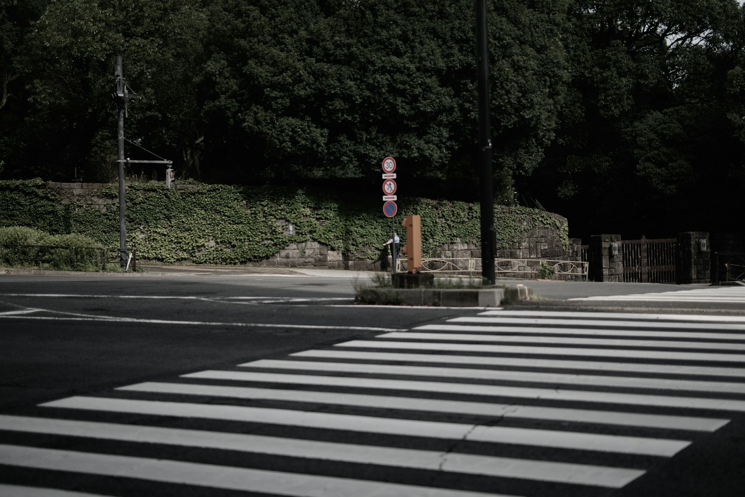 มุมถนนเงียบสงบที่มีทางข้ามและป้ายในพื้นหลังมืด