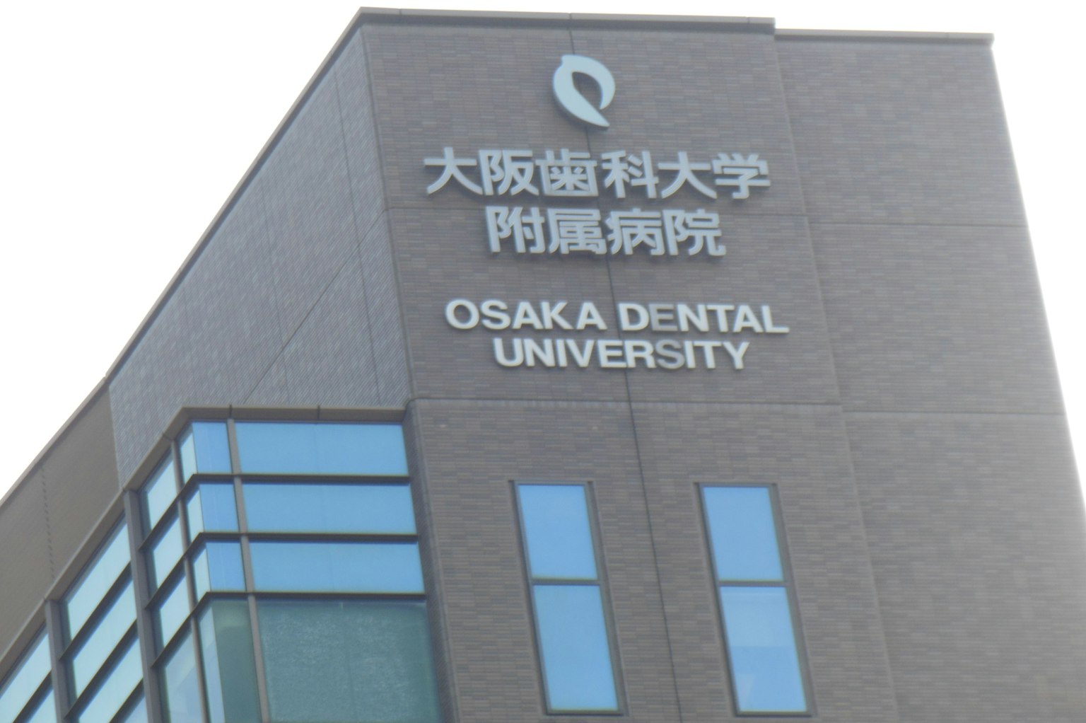 Außenansicht der Osaka Dental University mit Logo