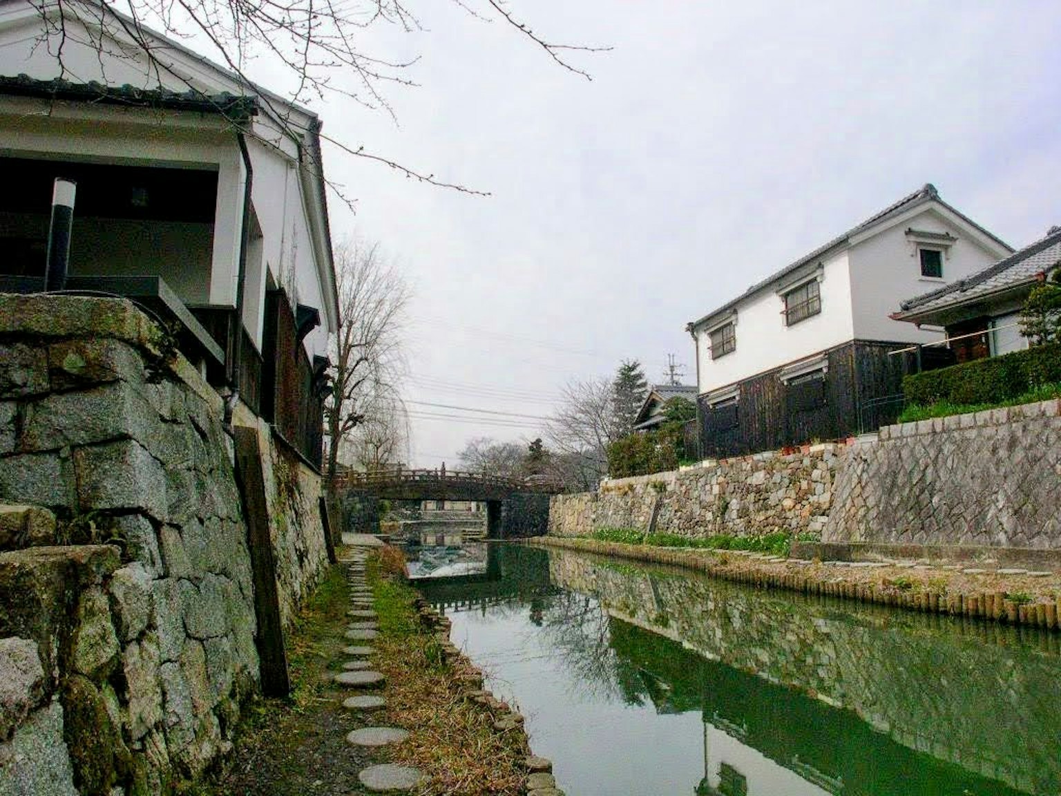 Scenic view of a tranquil canal with traditional Japanese buildings