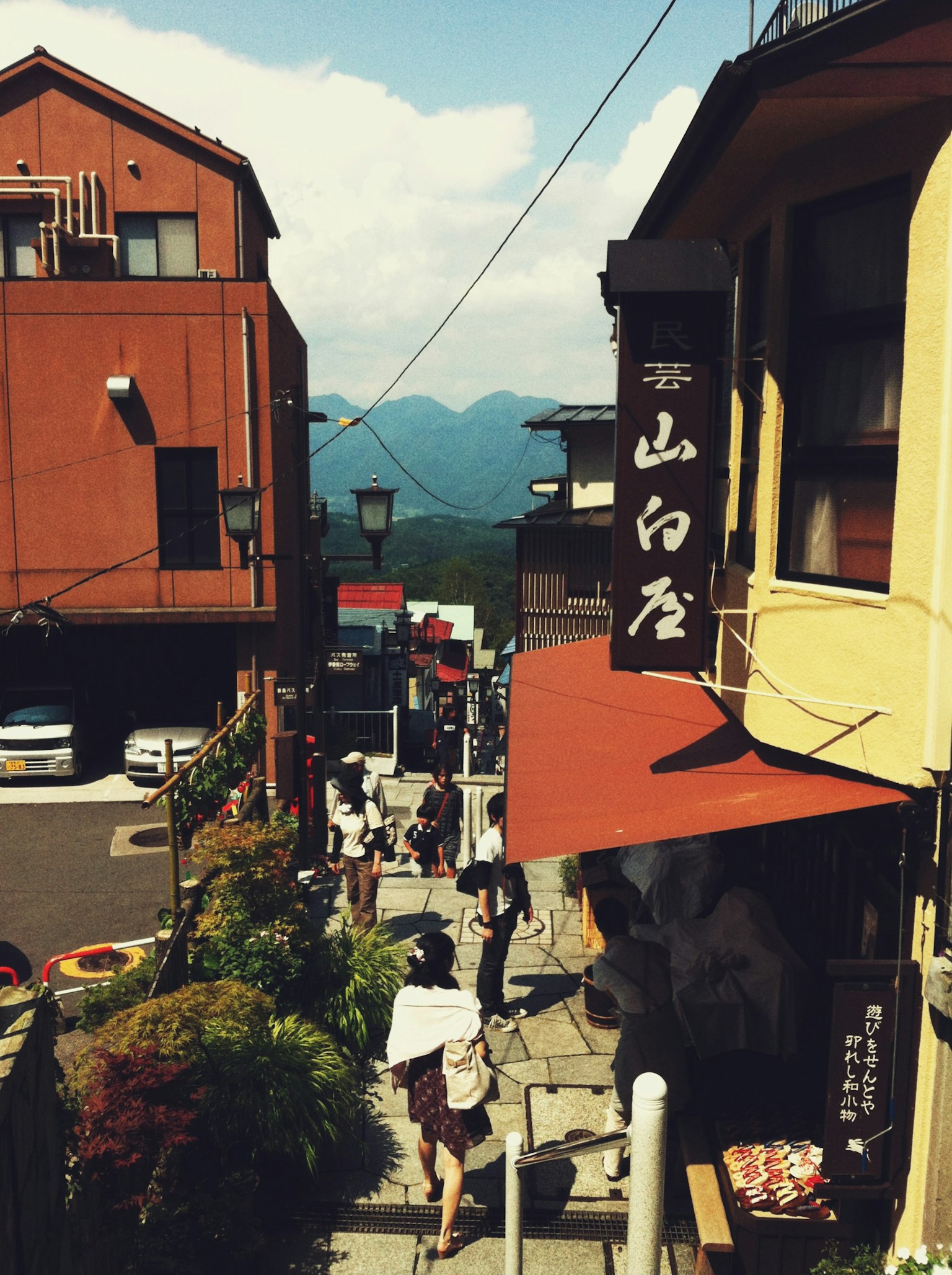 Bustling street scene with mountain backdrop and traditional buildings
