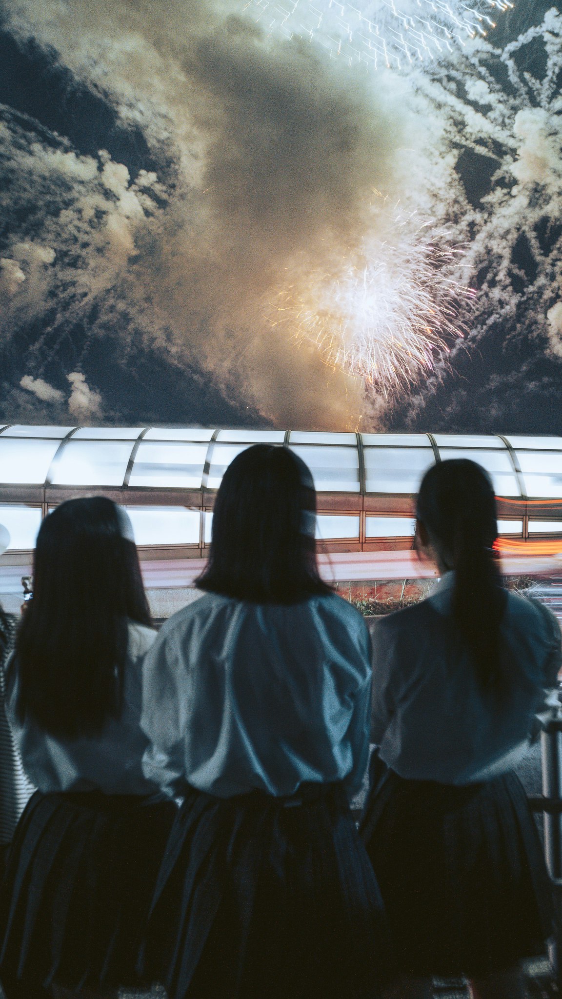 噴煙と爆発的な炎が見える火山のような自然現象を眺める人々