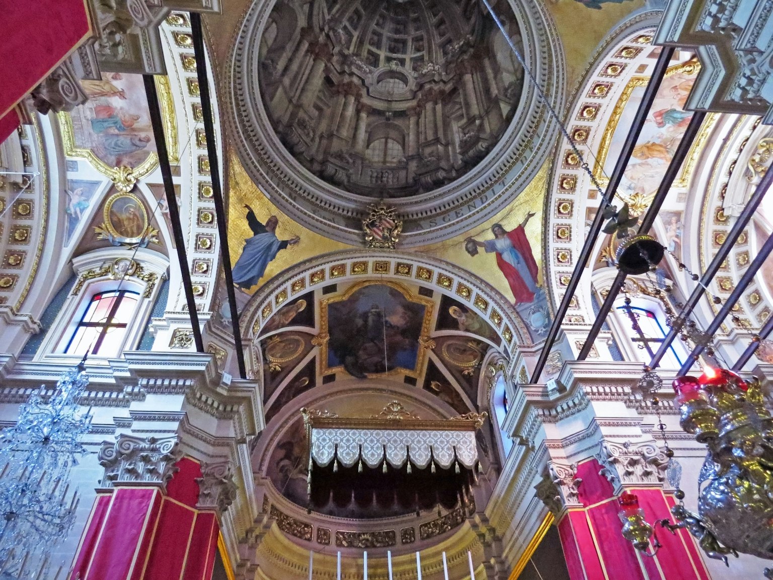 Innenansicht einer Kirche mit kunstvollen Deckenverzierungen und lebhaften Wandfarben