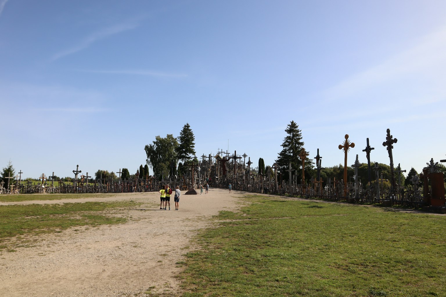 Paysage avec de nombreuses croix sur une colline et des personnes marchant