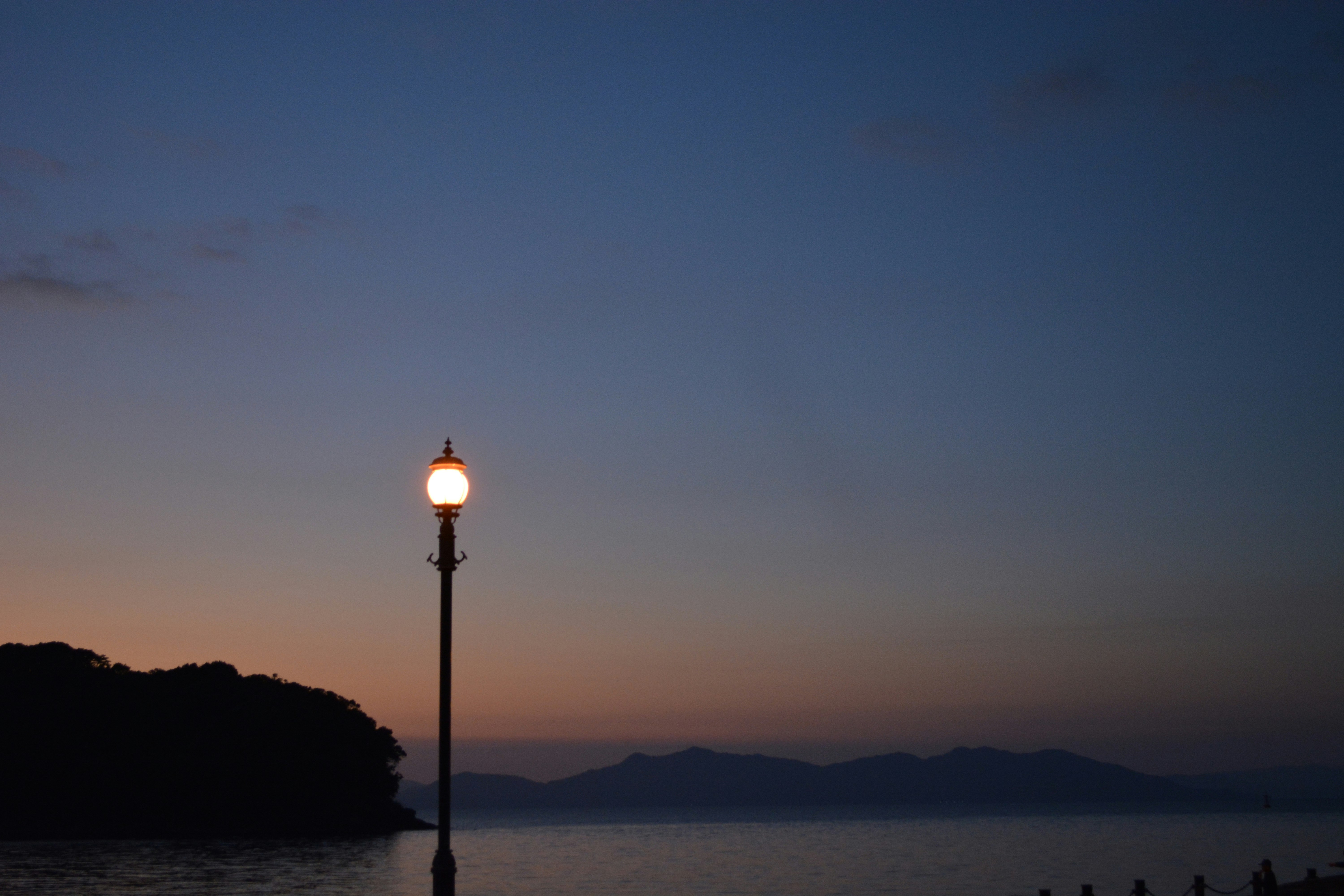 streetlamp by the seaside at dusk with a distant horizon