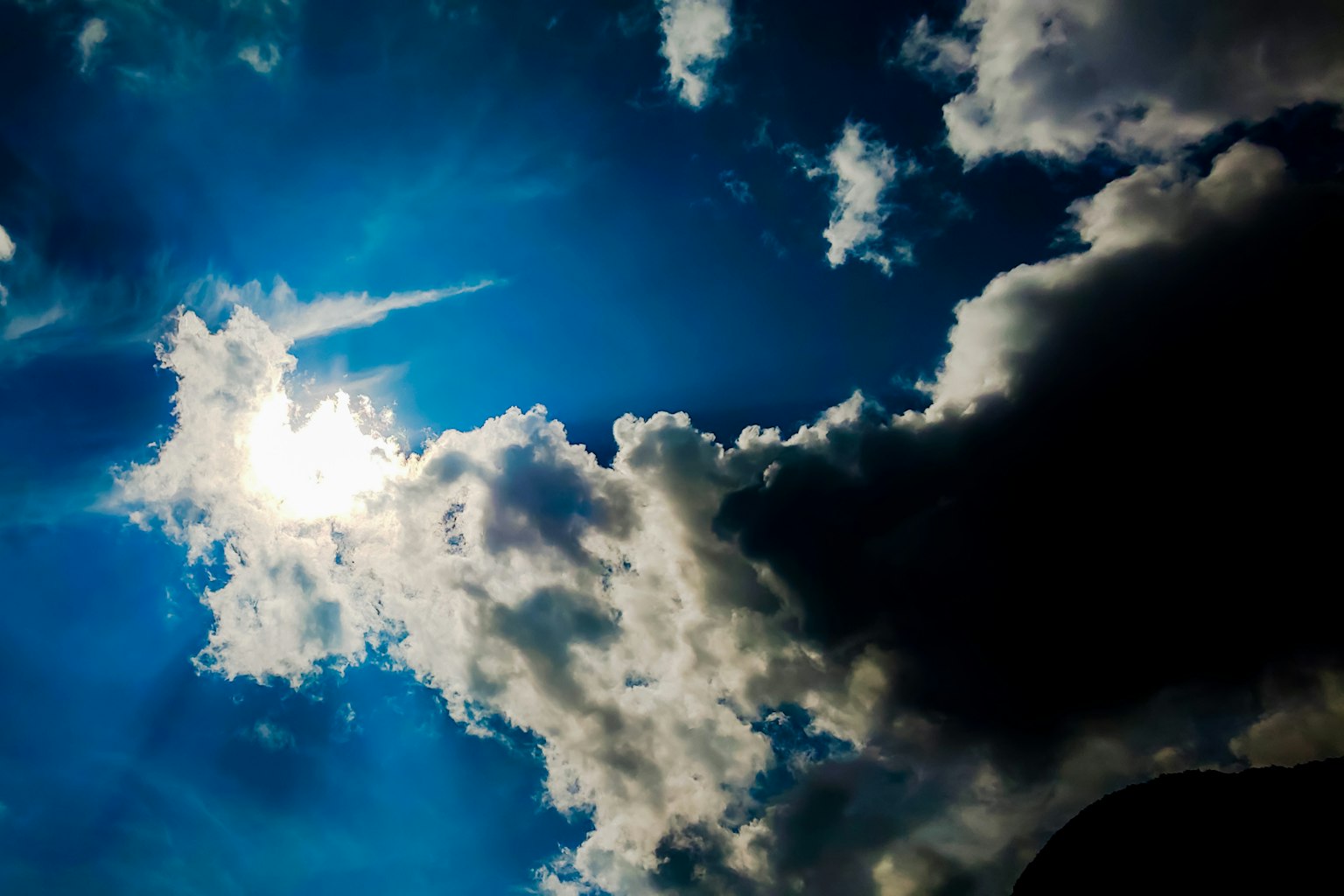 Contrast of white clouds against a blue sky with dark clouds