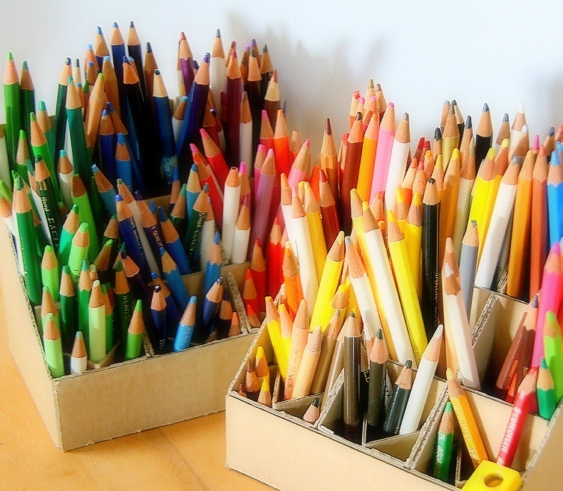 Colorful pencils arranged in boxes on a tabletop