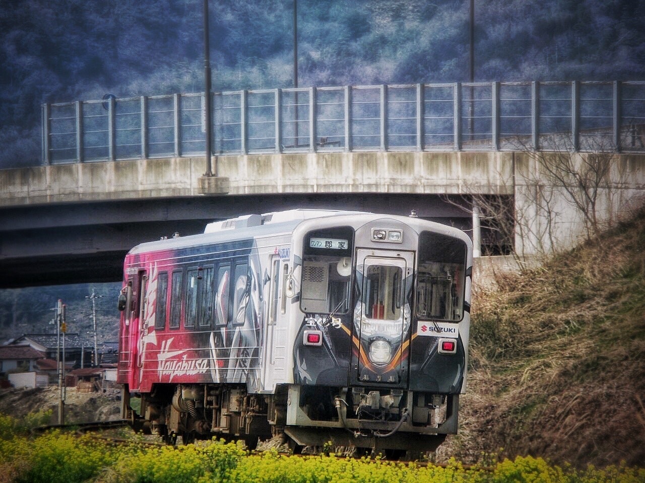 若桜鉄道のディーゼル列車が川沿いの線路を走る風景