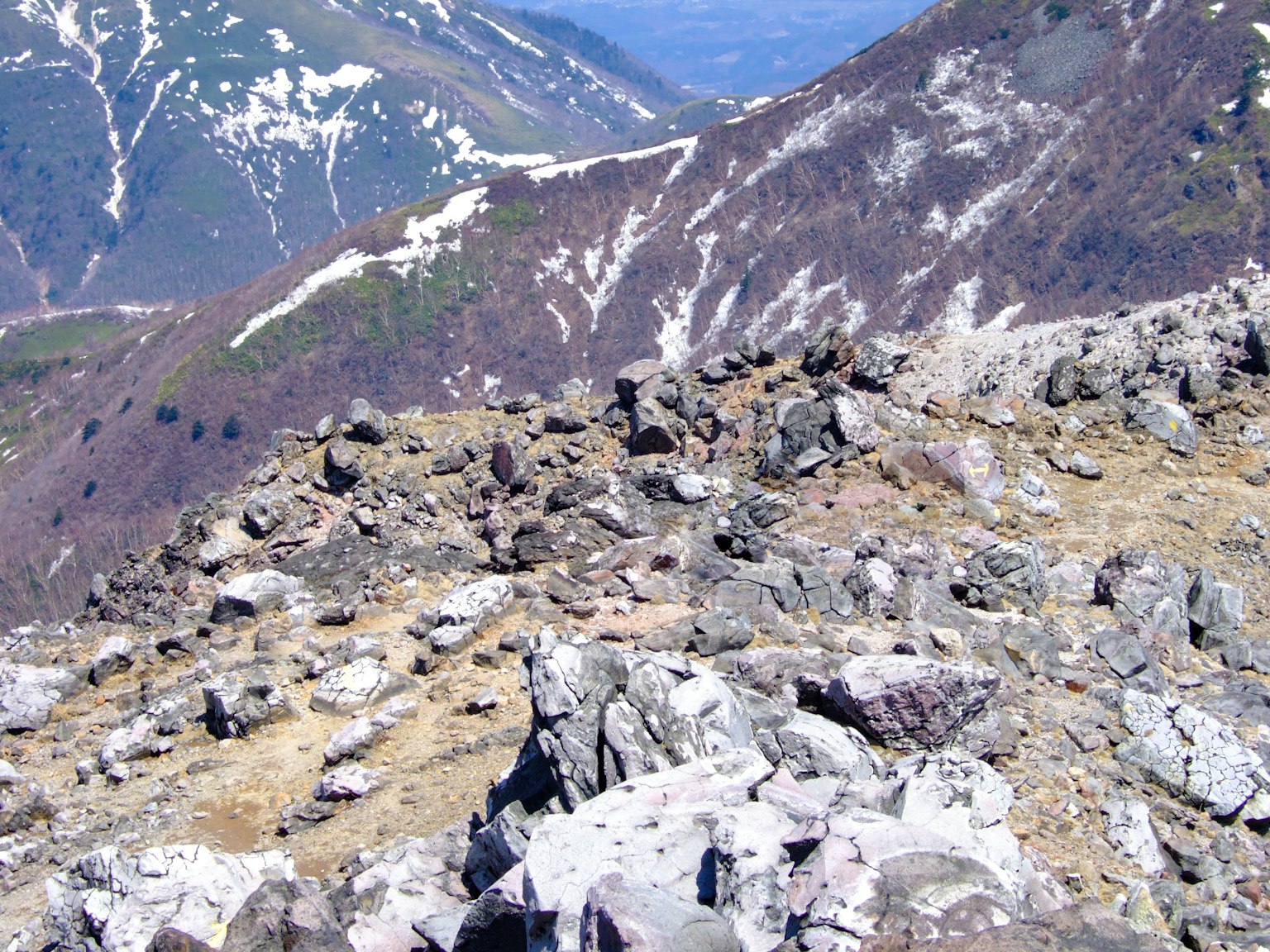 View from rocky terrain overlooking snow-capped mountains
