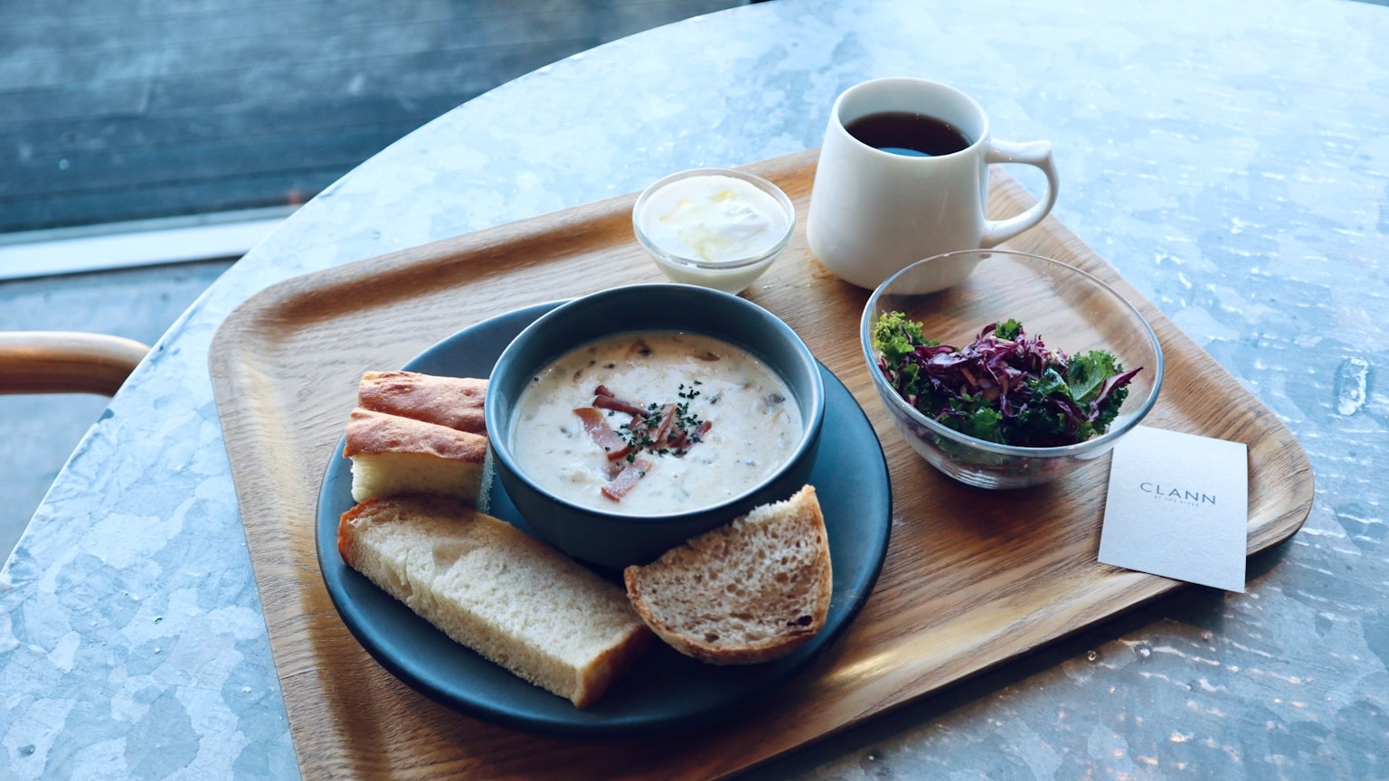 Bữa ăn gồm súp, salad, bánh mì và cà phê trên bàn