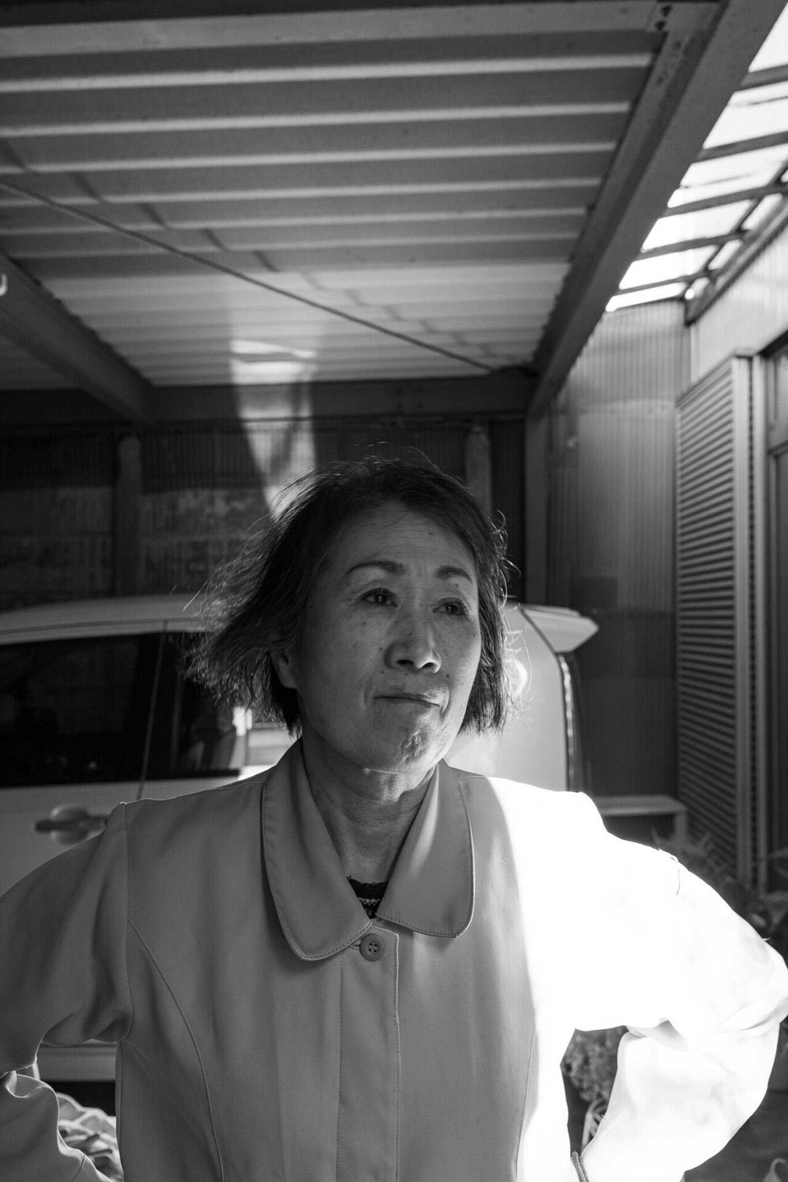 Black and white photo of a middle-aged woman standing thoughtfully