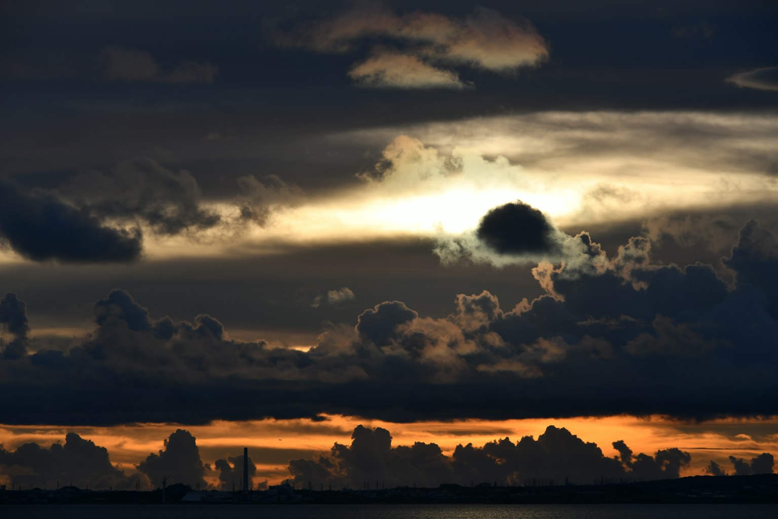 Cielo de atardecer dramático con nubes oscuras y un sol brillante