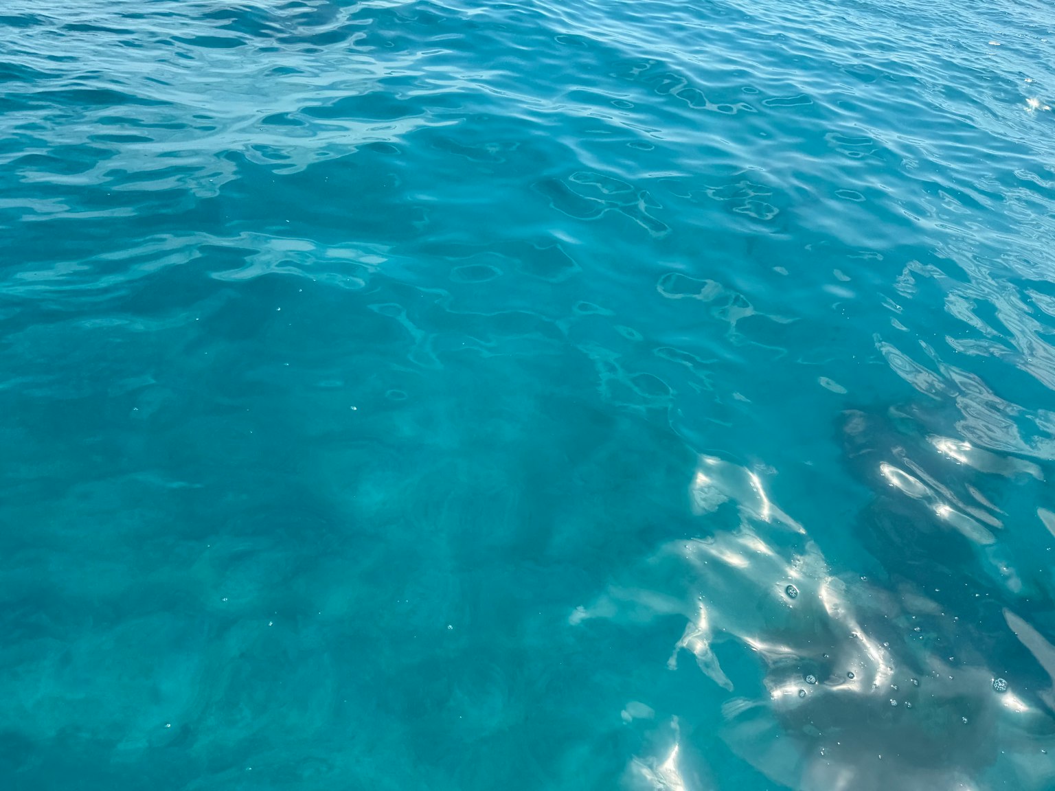 Surface de l'eau de l'océan bleu reflétant la lumière du soleil