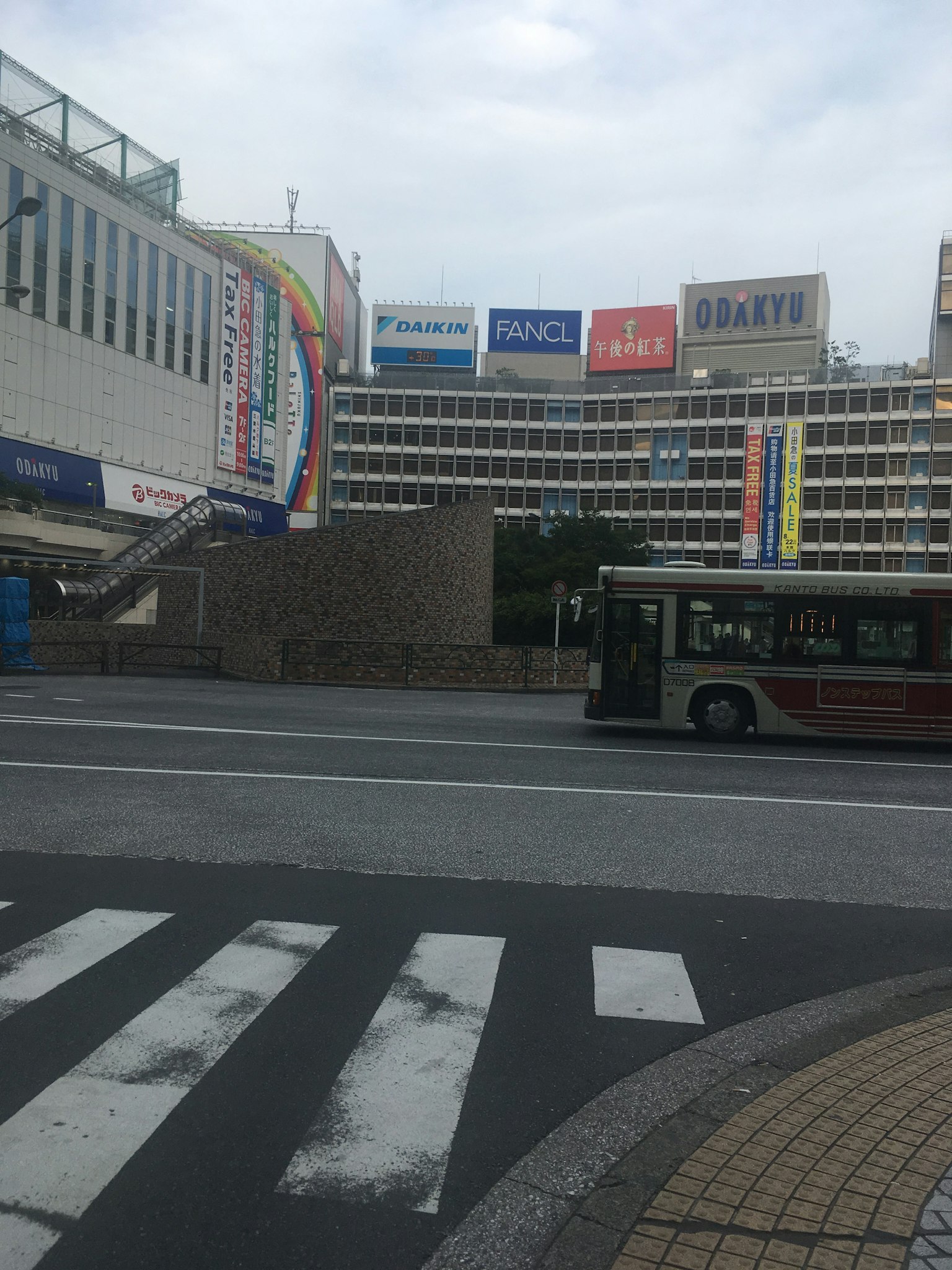 View of a bus stop with advertisements near a station