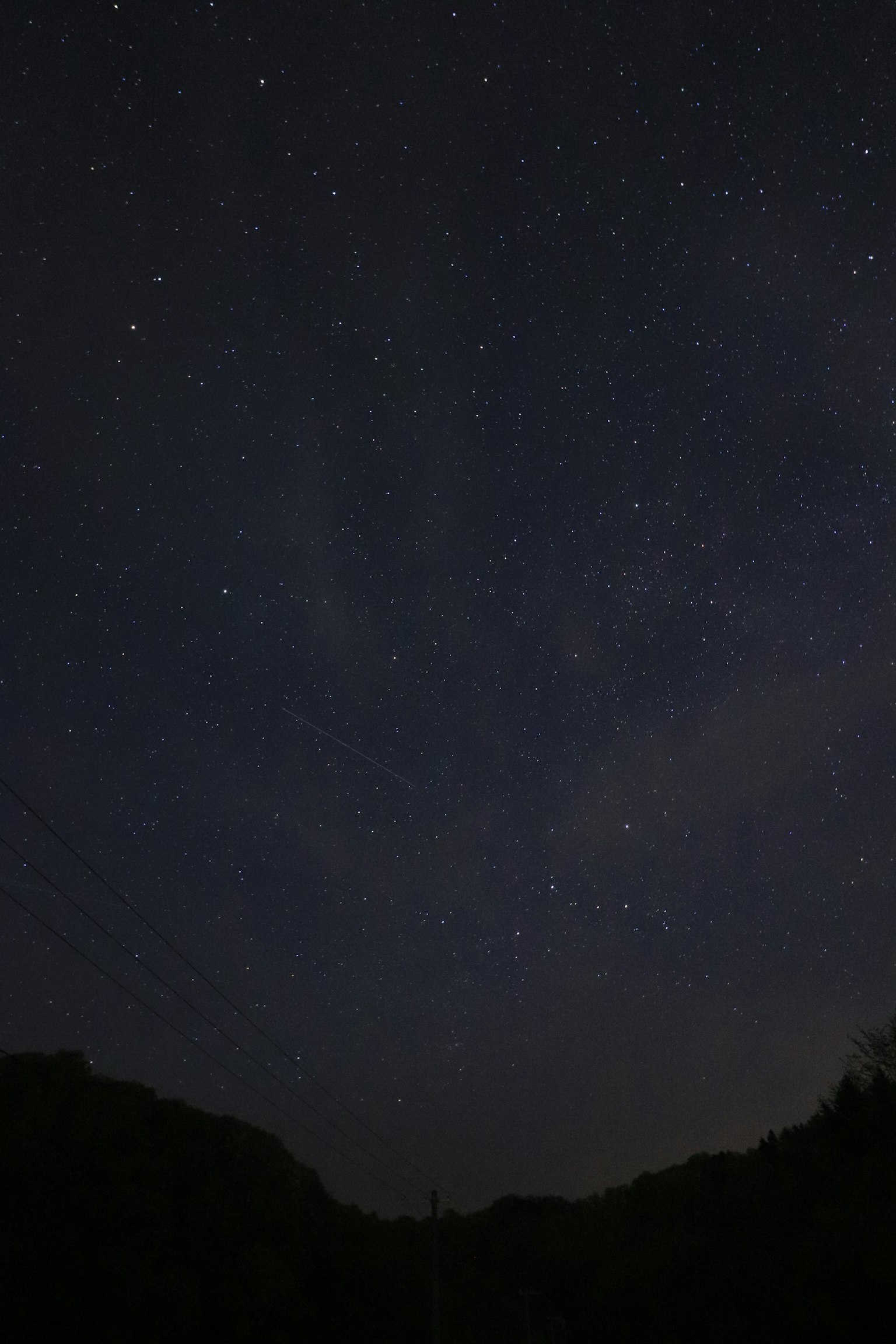 Foto di un cielo notturno stellato con silhouette di montagne