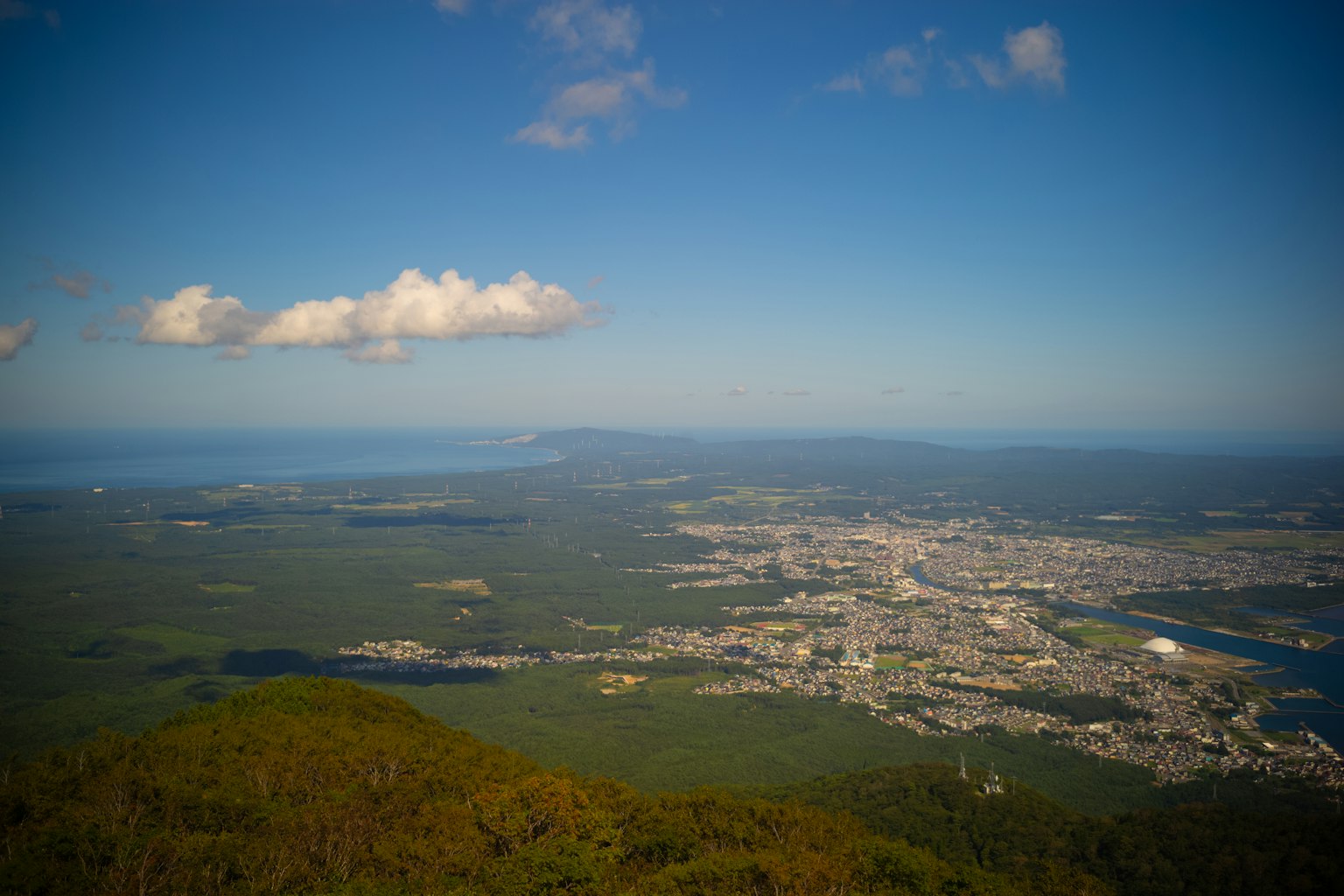 Una vista panoramica da una montagna che mostra una città e il mare