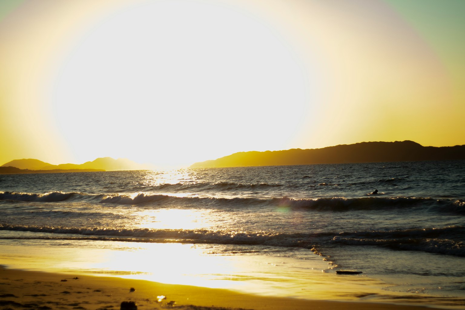 Magnifique coucher de soleil sur l'océan avec des reflets sur la plage et les vagues