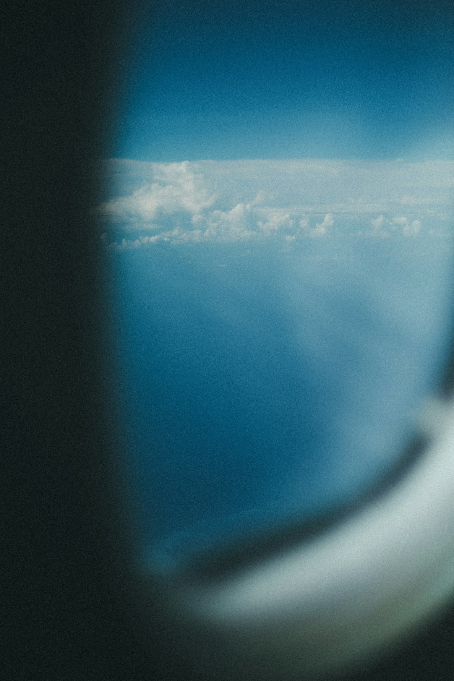Vista dell'oceano blu e delle nuvole bianche da un finestrino di aereo
