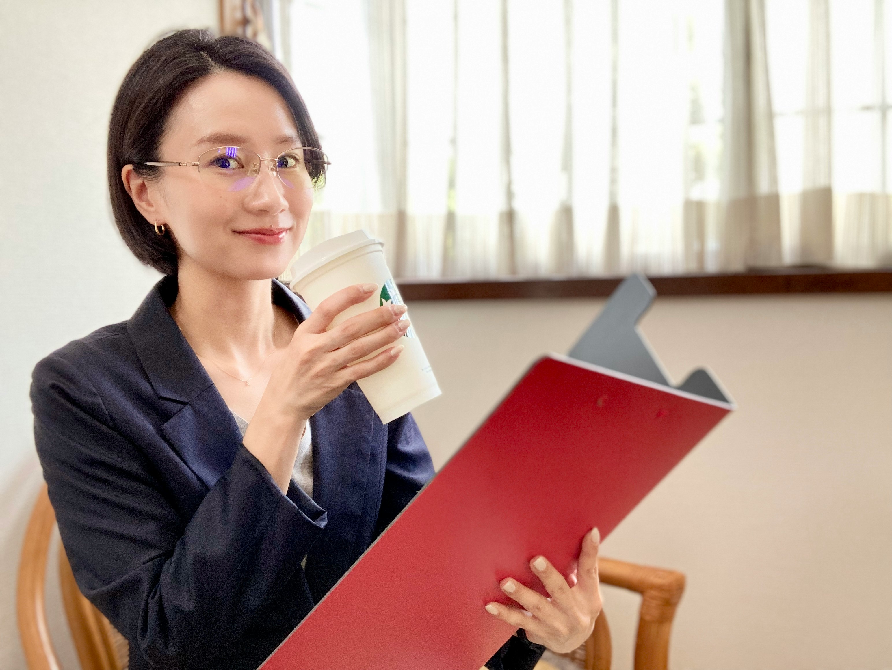 femme tenant des documents et buvant un café au bureau