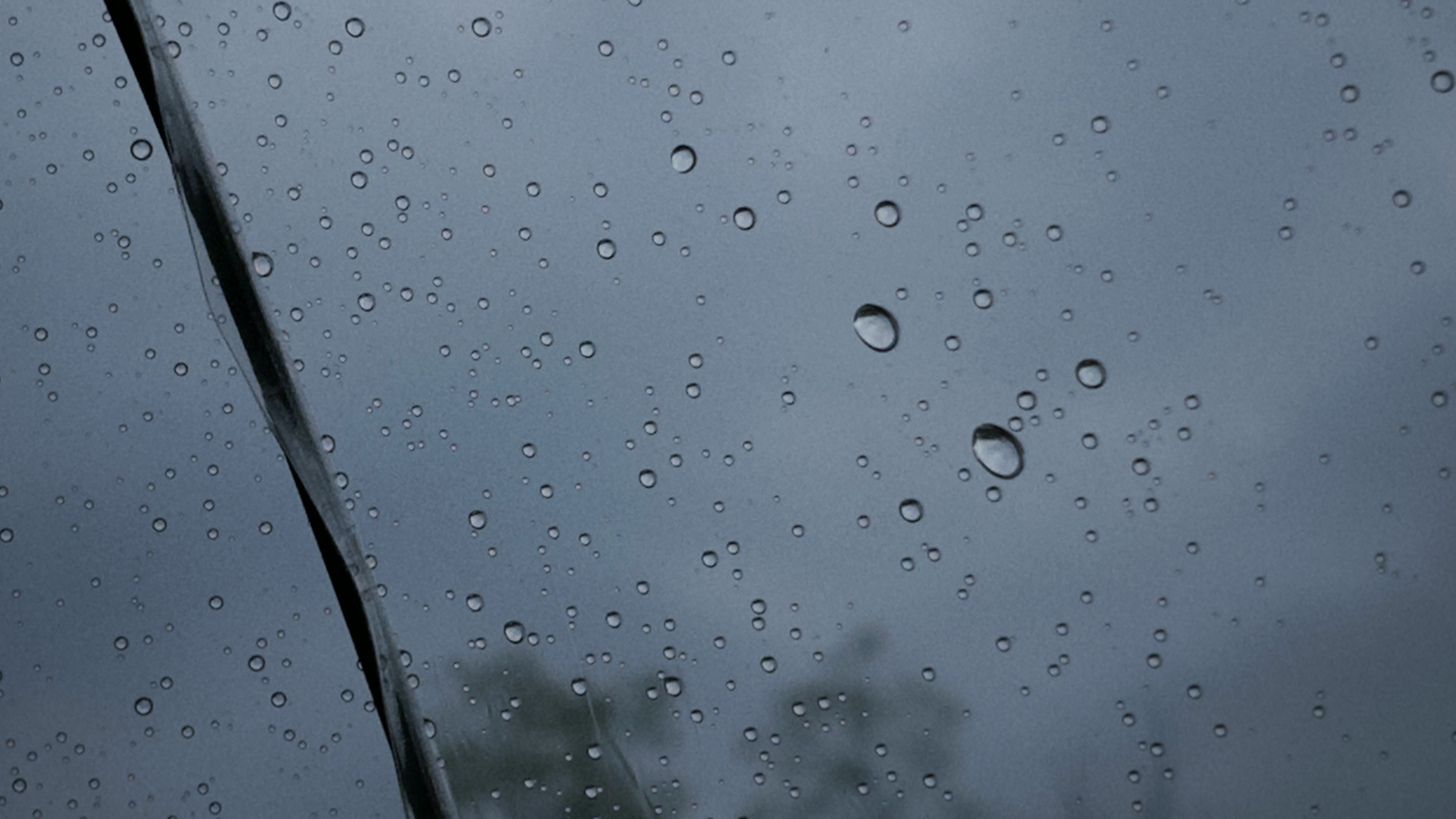雨粒の付いた窓ガラス越しの霧のかかった空