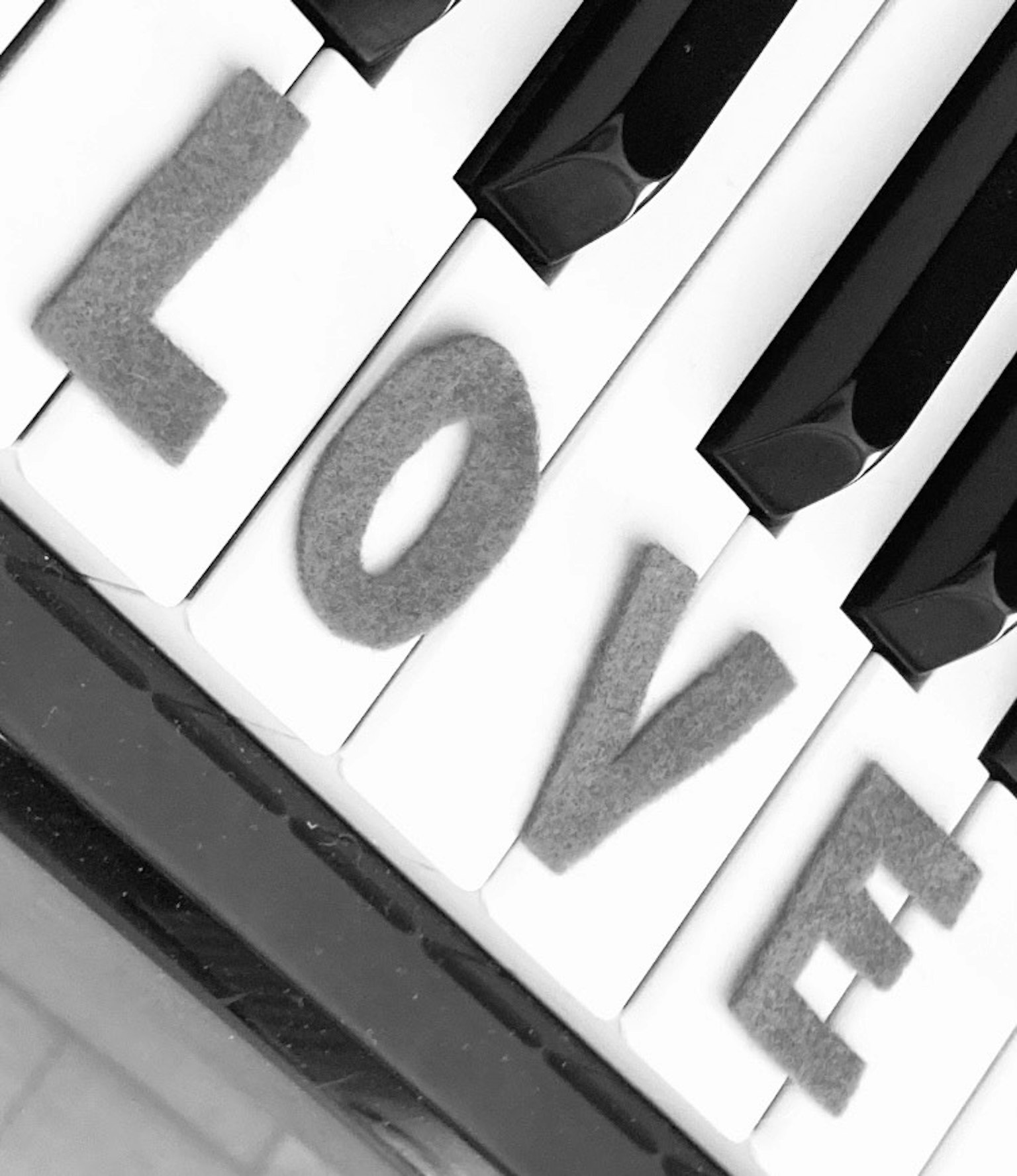 Lettere che formano la parola amore su una tastiera di pianoforte in bianco e nero