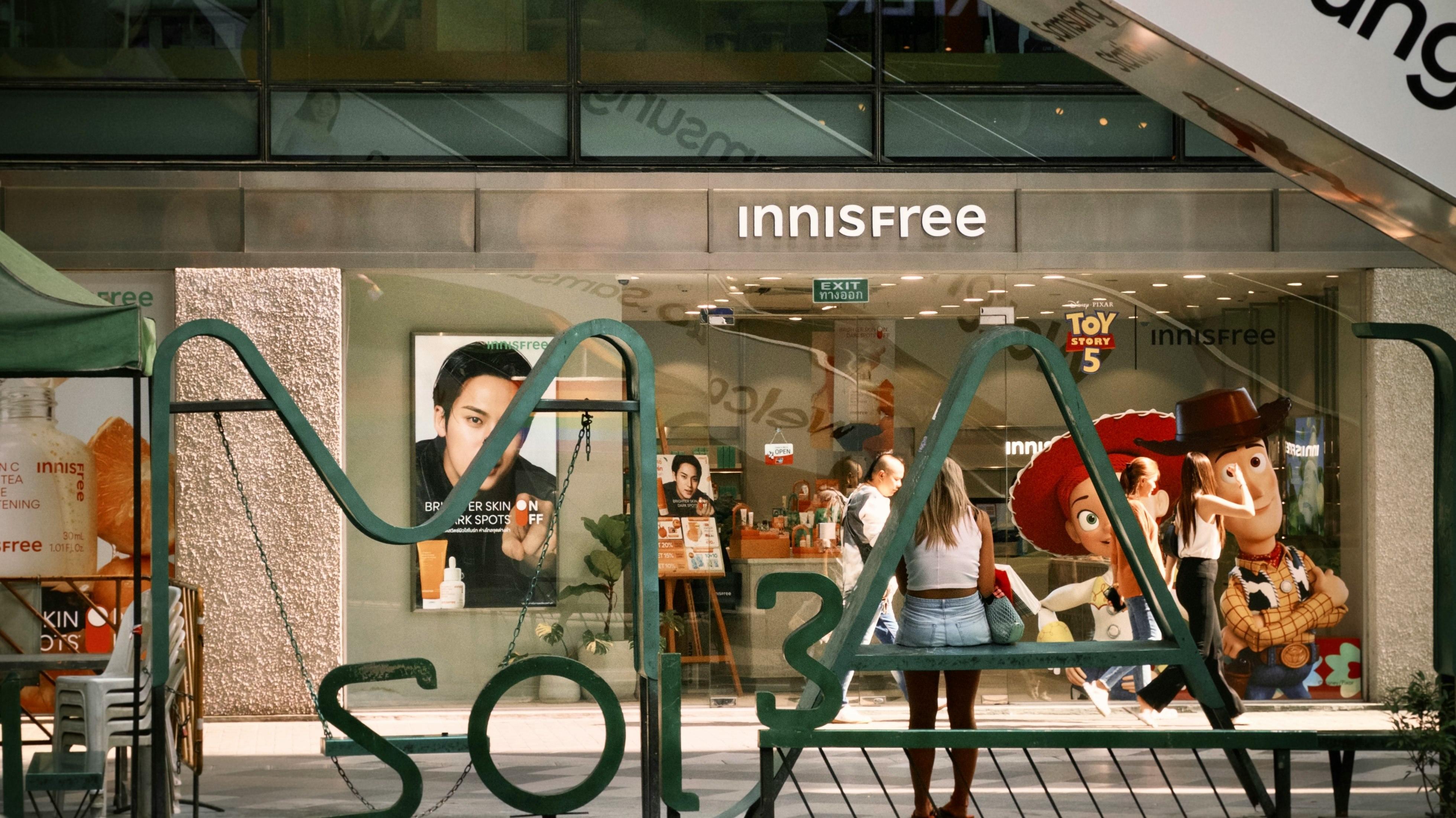 「innisfree」店先のガラス越しに見える人とディスプレイ