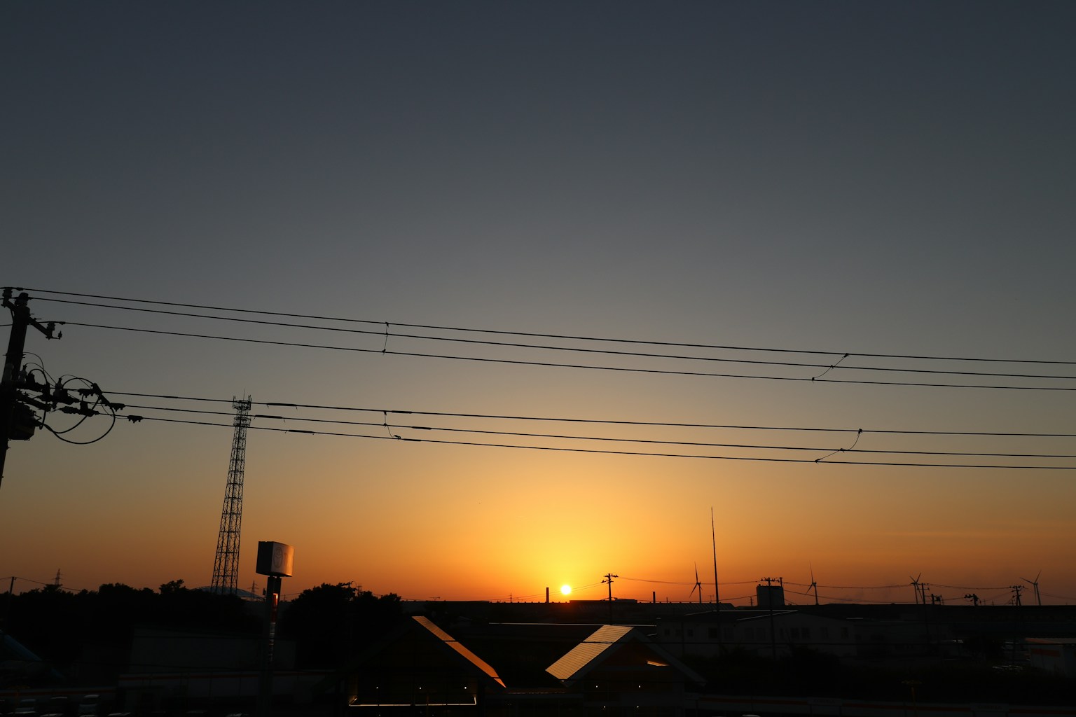 Tramonto all'orizzonte con silhouette di linee elettriche