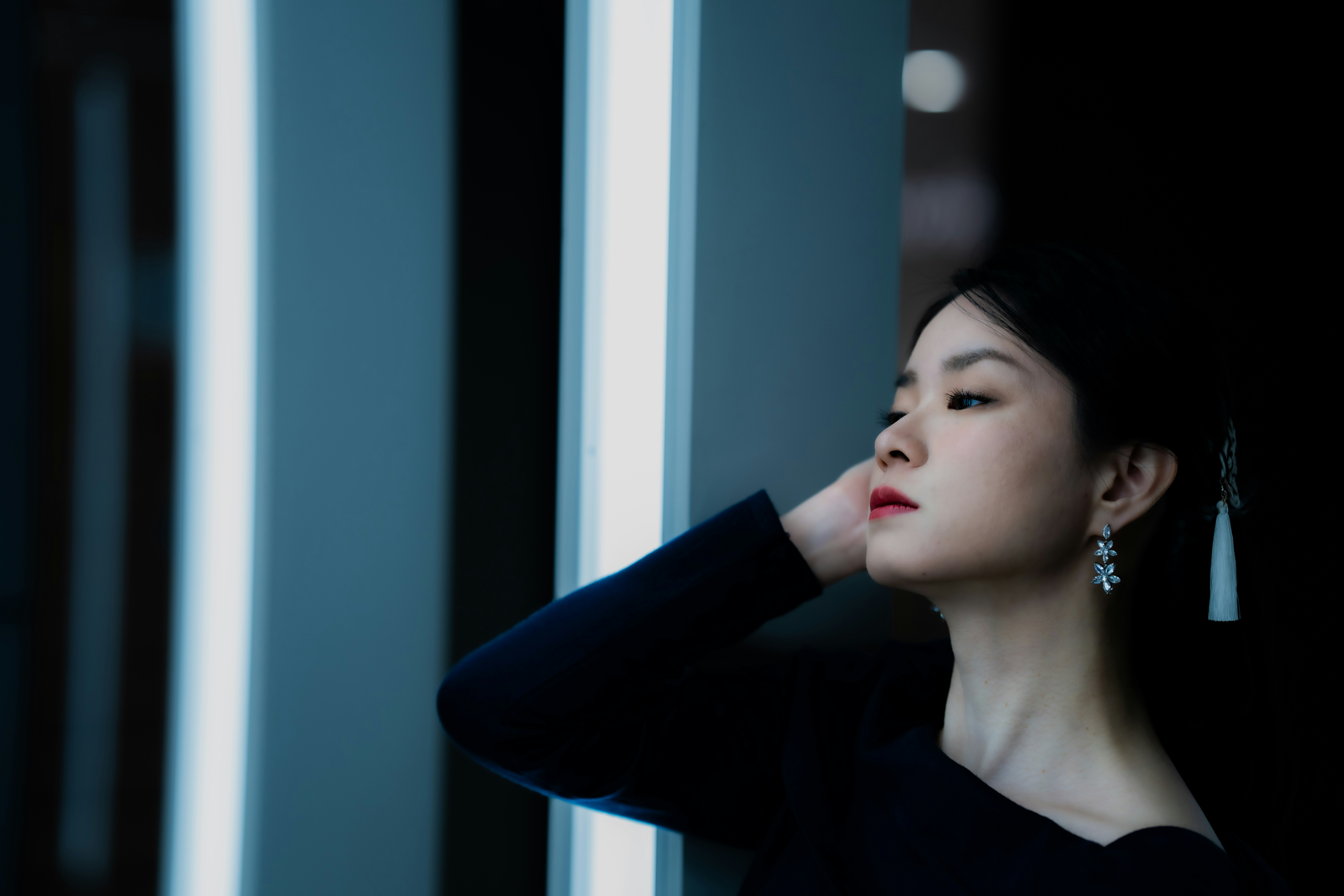 女性がネオンライトの前でポーズをとっている写真