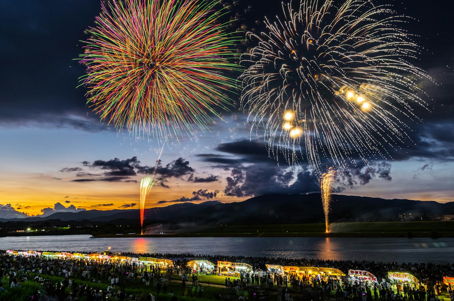 Spectacular fireworks illuminating the night sky over a river