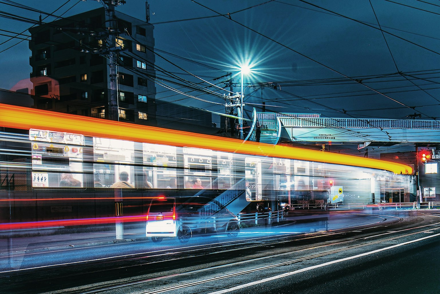 Paesaggio urbano notturno con un treno in movimento e scie di luce