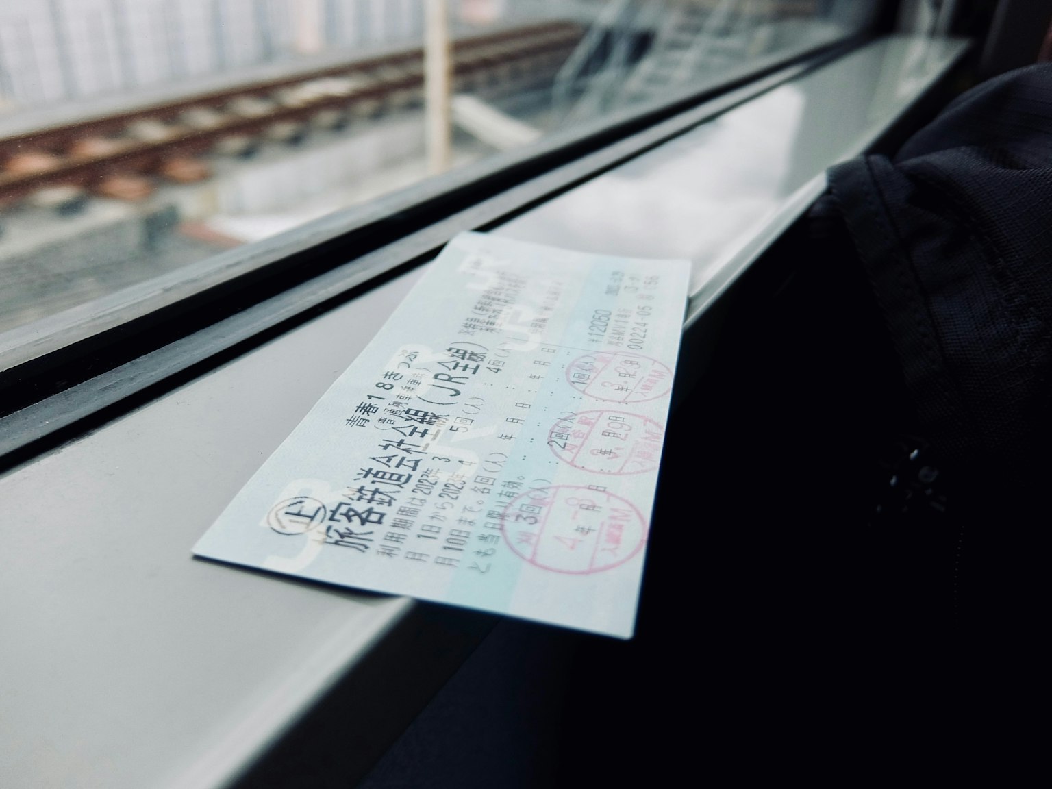Close-up tiket kereta api yang terletak di ambang jendela