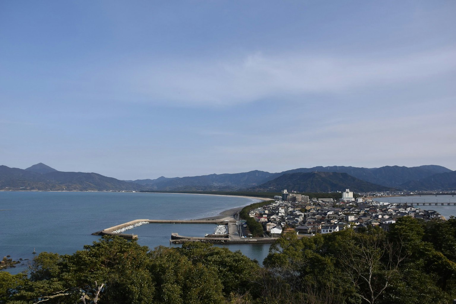 Vista panorámica de un pueblo costero con montañas al fondo