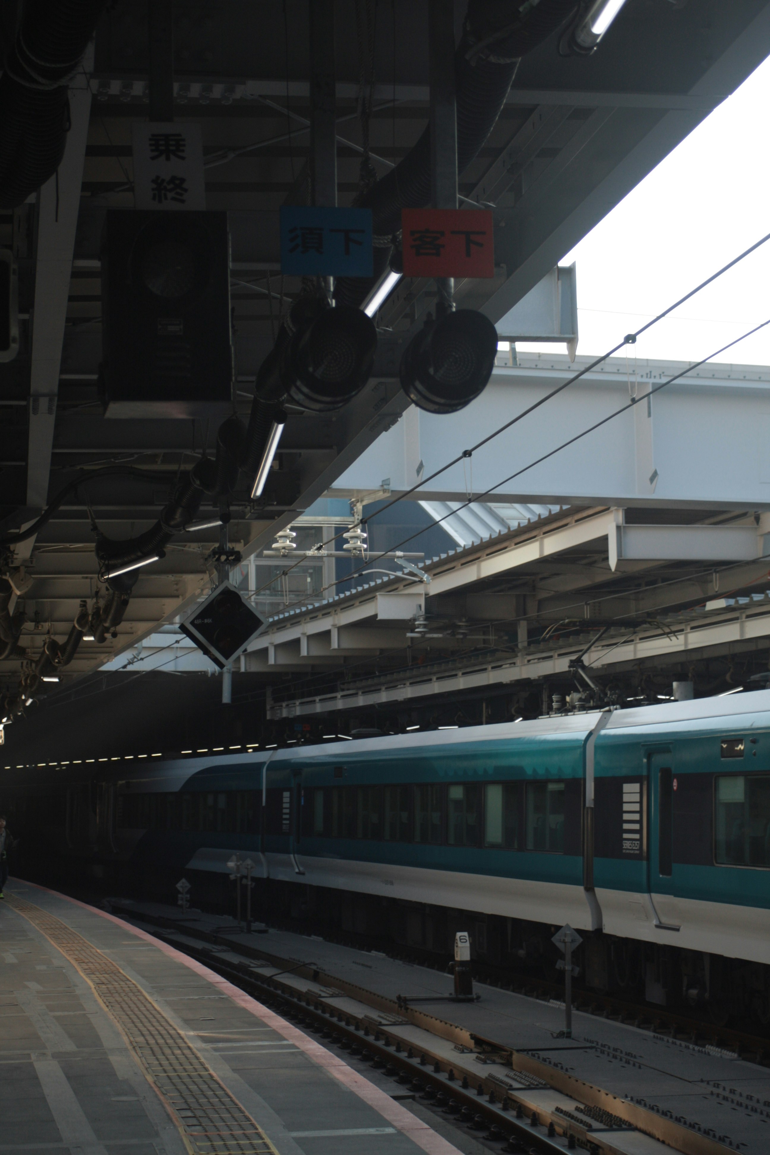 高架下のホームで停車する電車のある駅風景