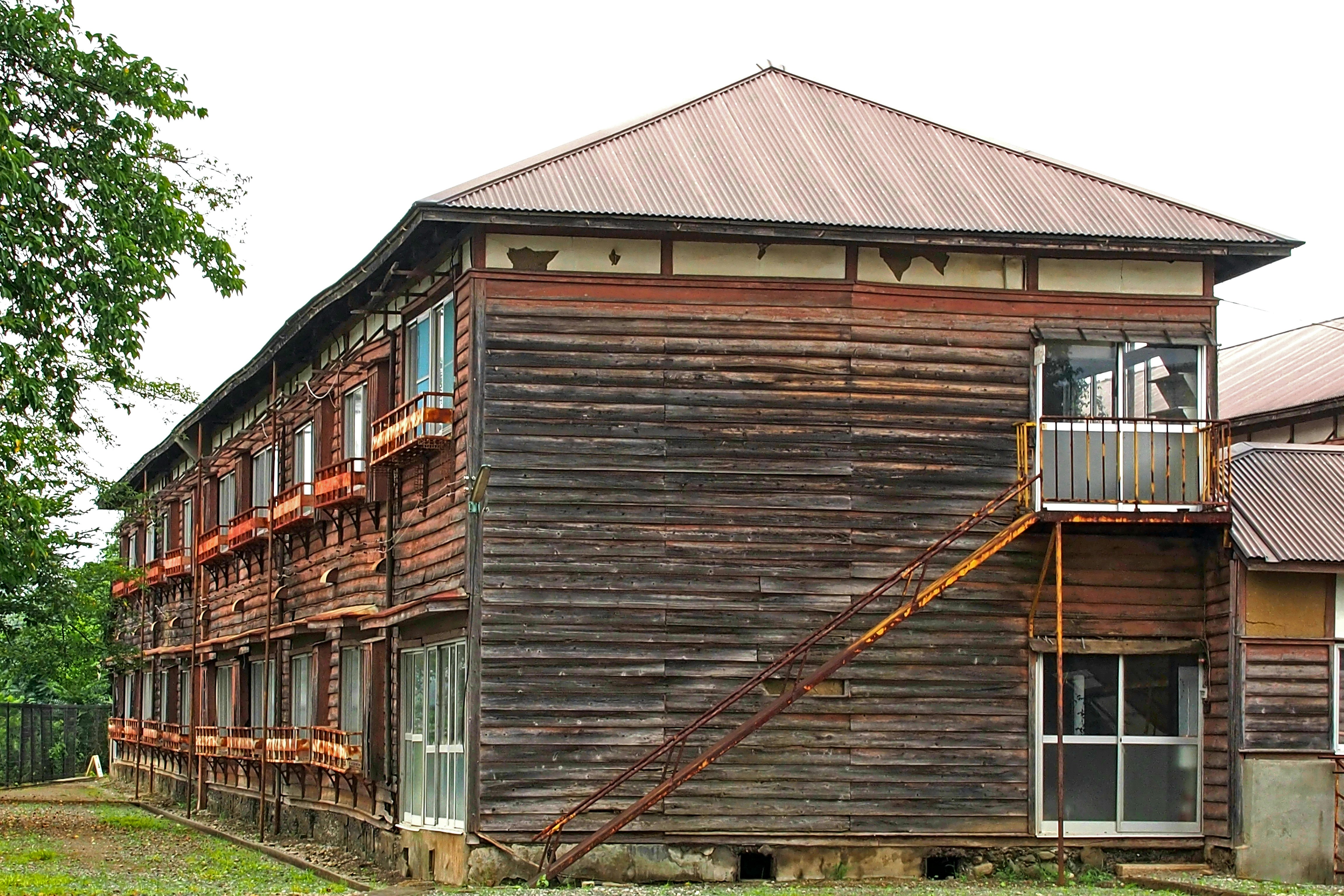 Exterior of a long wooden building with rows of windows