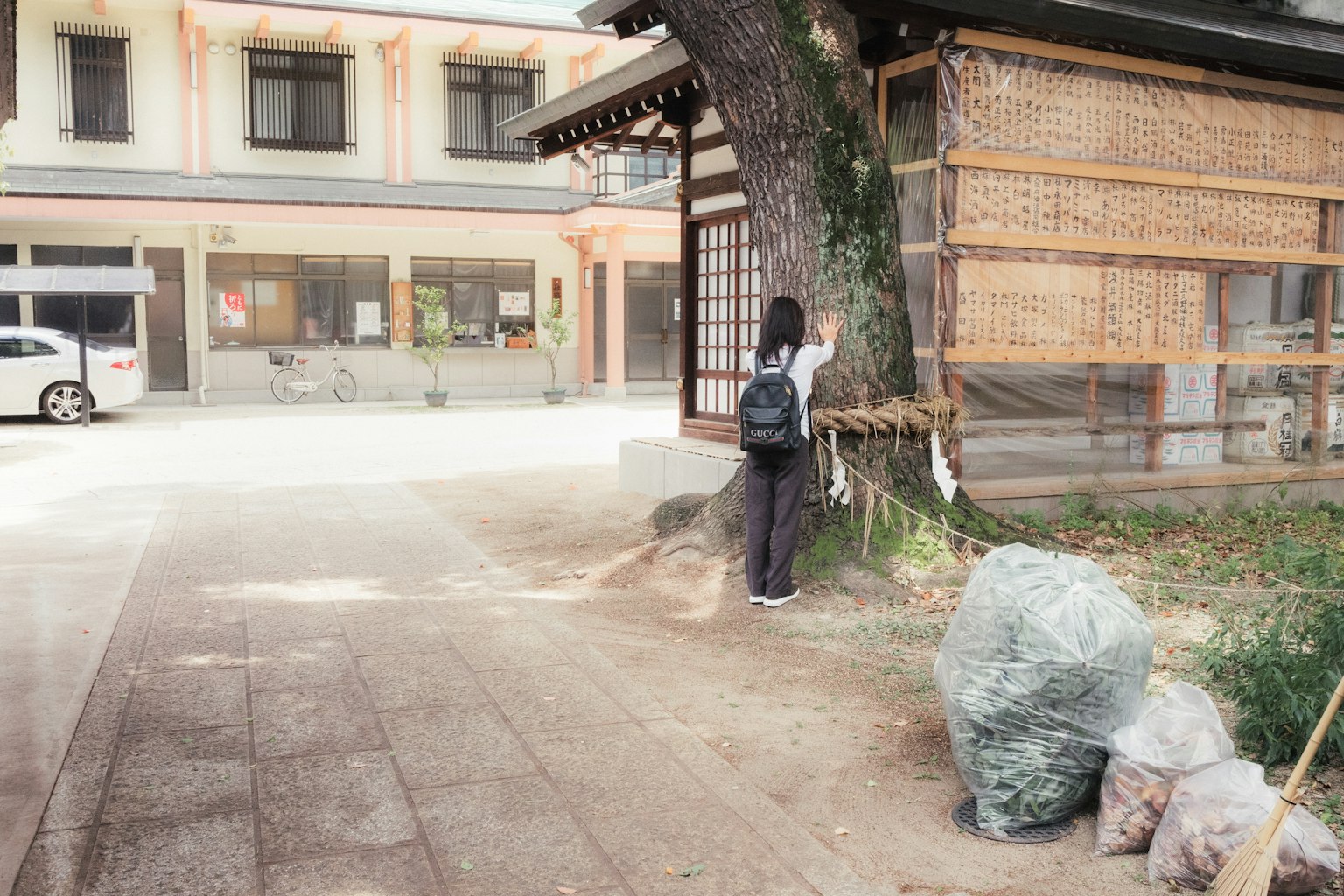 Enfant debout près d'un vieux bâtiment et d'un arbre