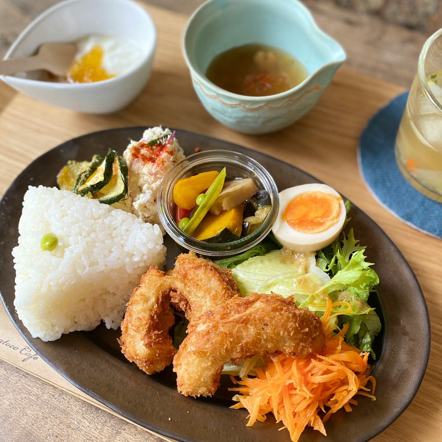炸蝦、白飯、沙拉、燉菜和溏心蛋的盤子