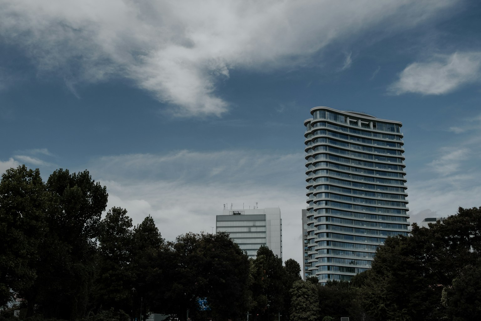 Moderne Gebäude unter einem blauen Himmel mit Wolken und umliegendem Grün