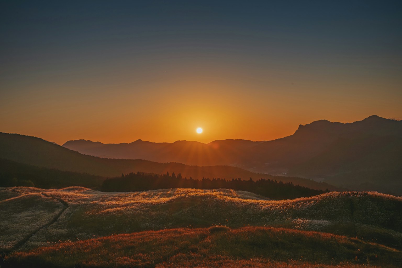 夕日が山々の間に沈む美しい風景