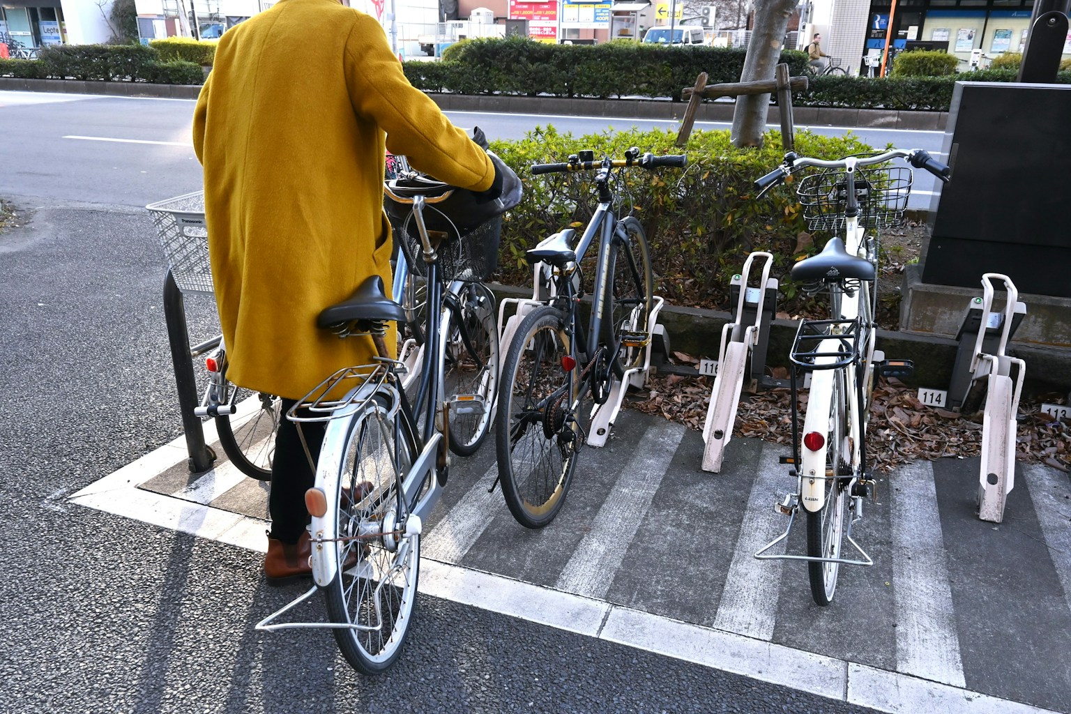 穿着黄色外套的人在自行车停车架上停车