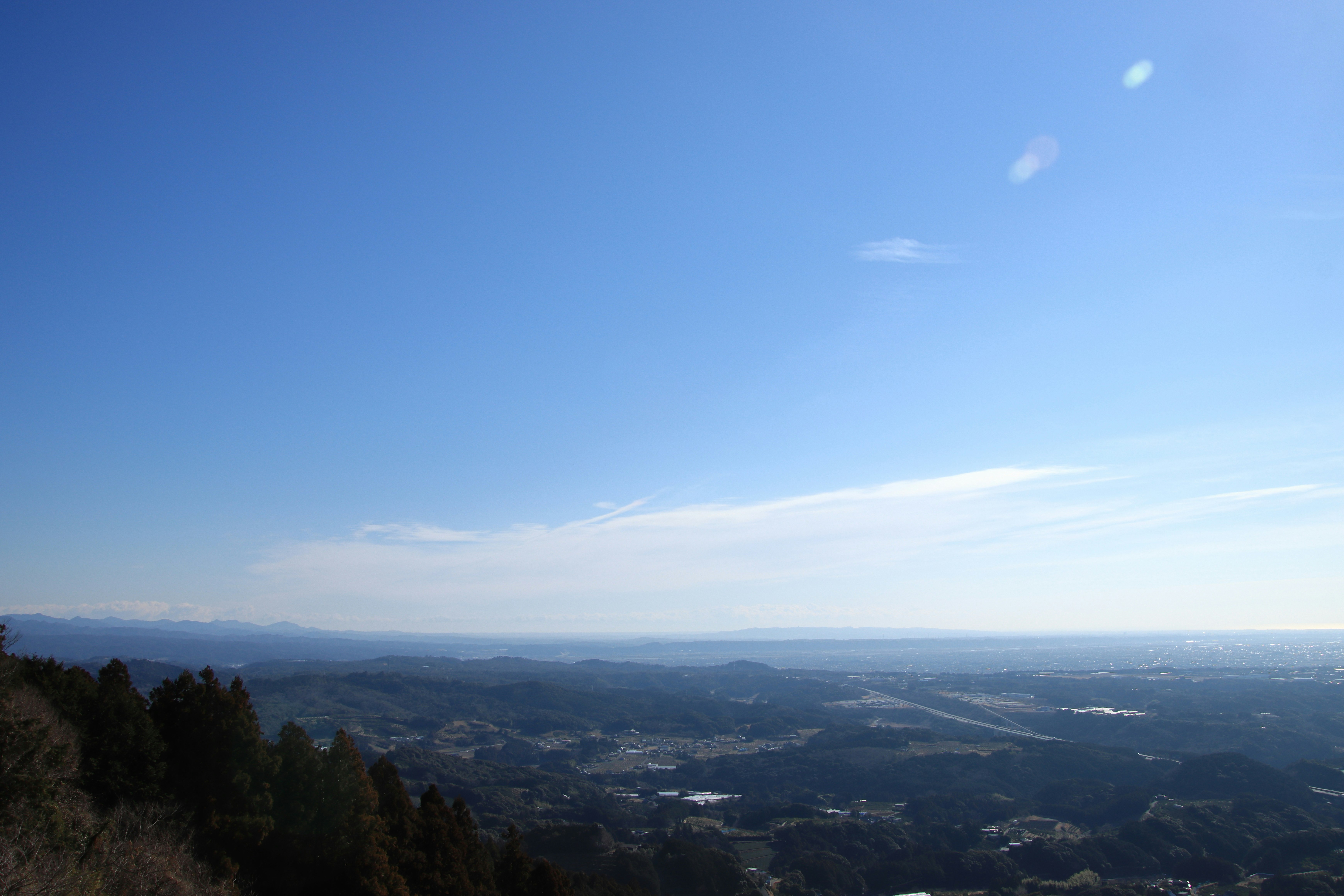 山の稜線から見渡す広大な渓谷と遠景の海