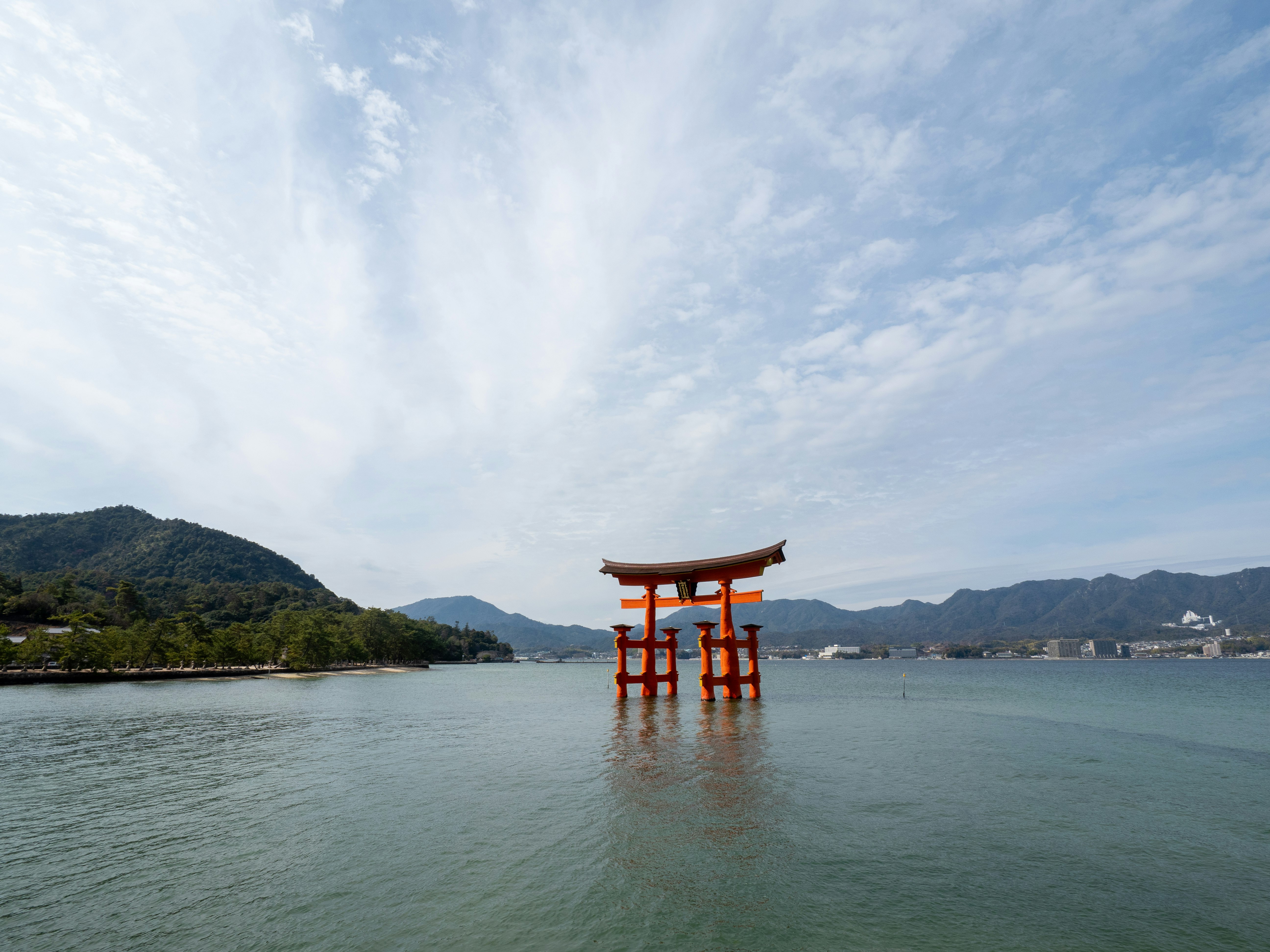 湖に浮かぶ朱色の鳥居と山並みの風景