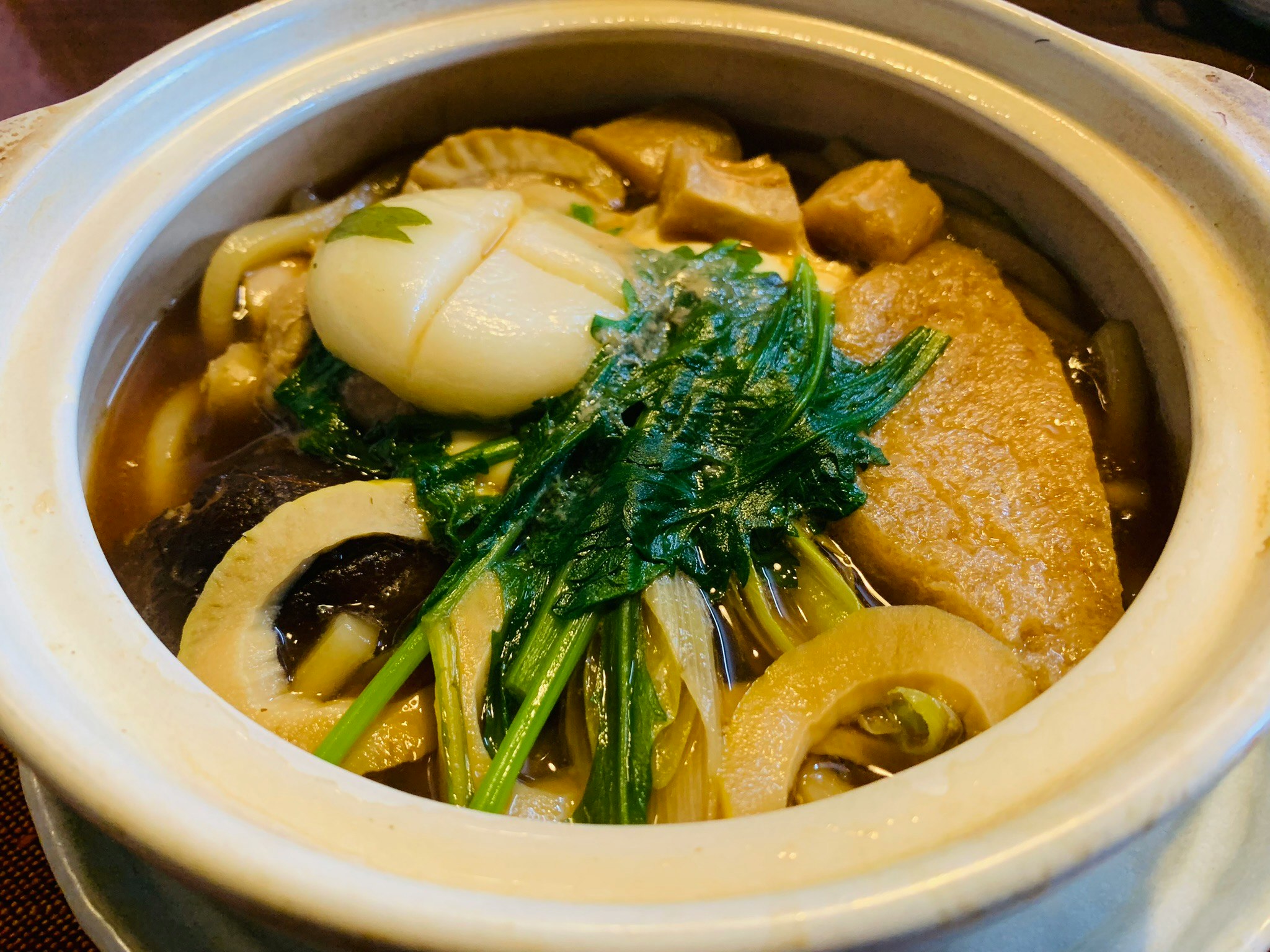 鍋焼きうどんの具材と卵がのった土鍋のアップ