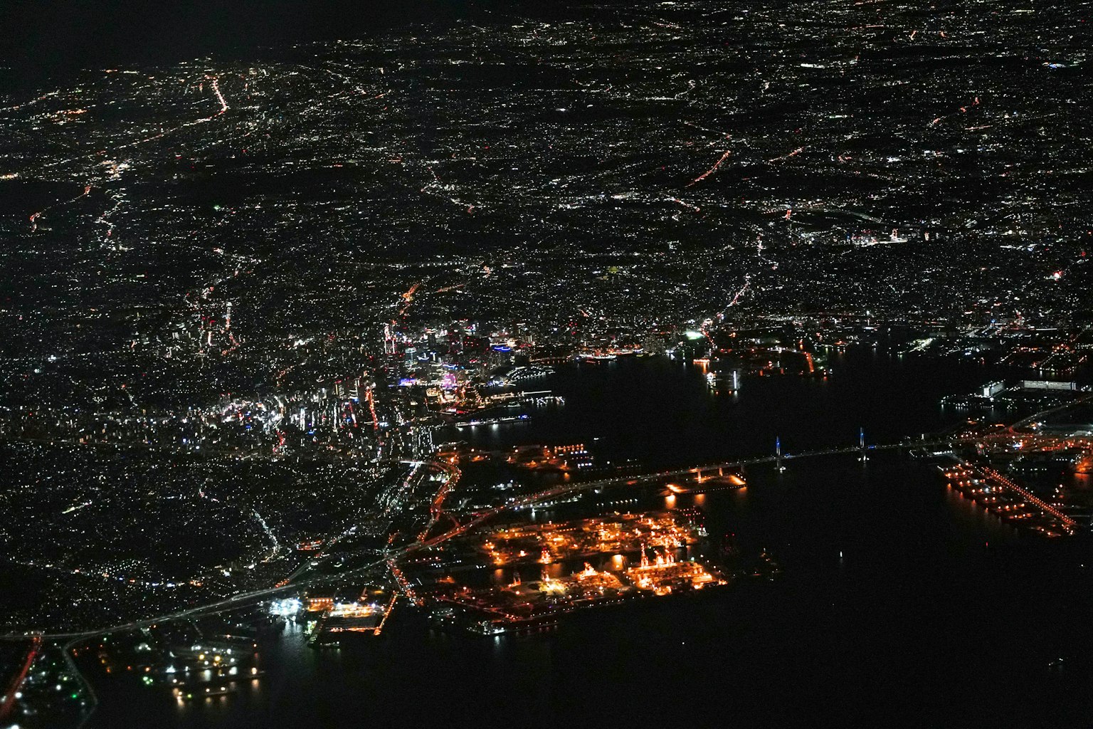 Vista aérea de una ciudad por la noche Luces brillantes iluminando el paisaje urbano y el puerto