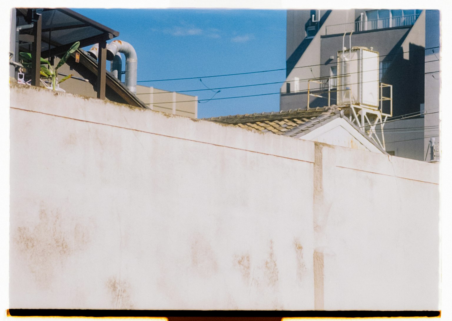 Mur blanc avec ciel bleu structures industrielles en arrière-plan